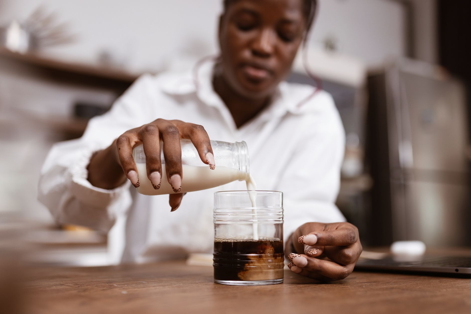 A close-up of a pregnant woman pouring pasteurized milk into a glass
