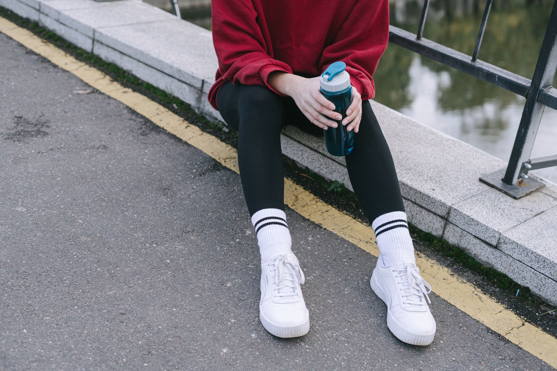 Pregnant traveler with compression socks and water bottle