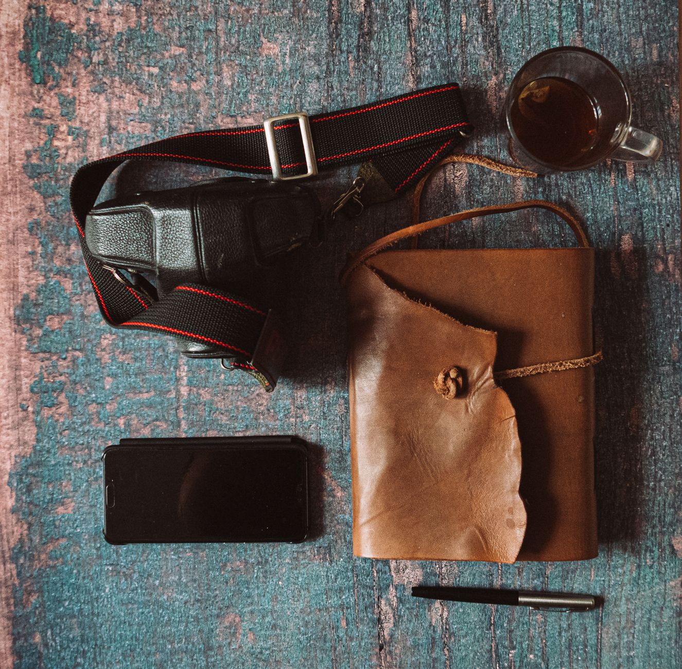 A cozy bedroom scene with a nightstand holding a water bottle, a phone, and a small notebook titled ‘Bleeding Tracker’