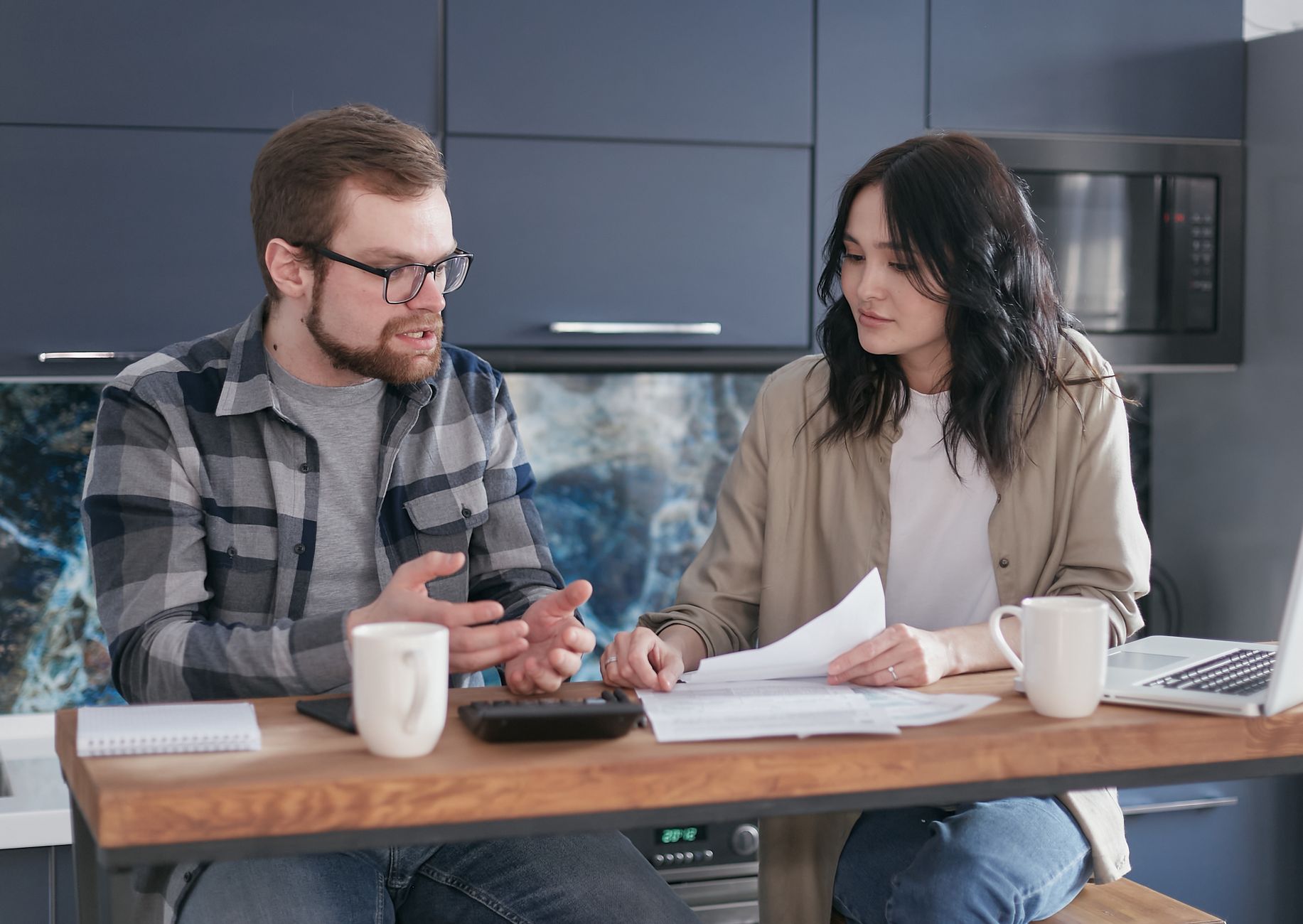 Couple planning parenting tasks together at a kitchen table.