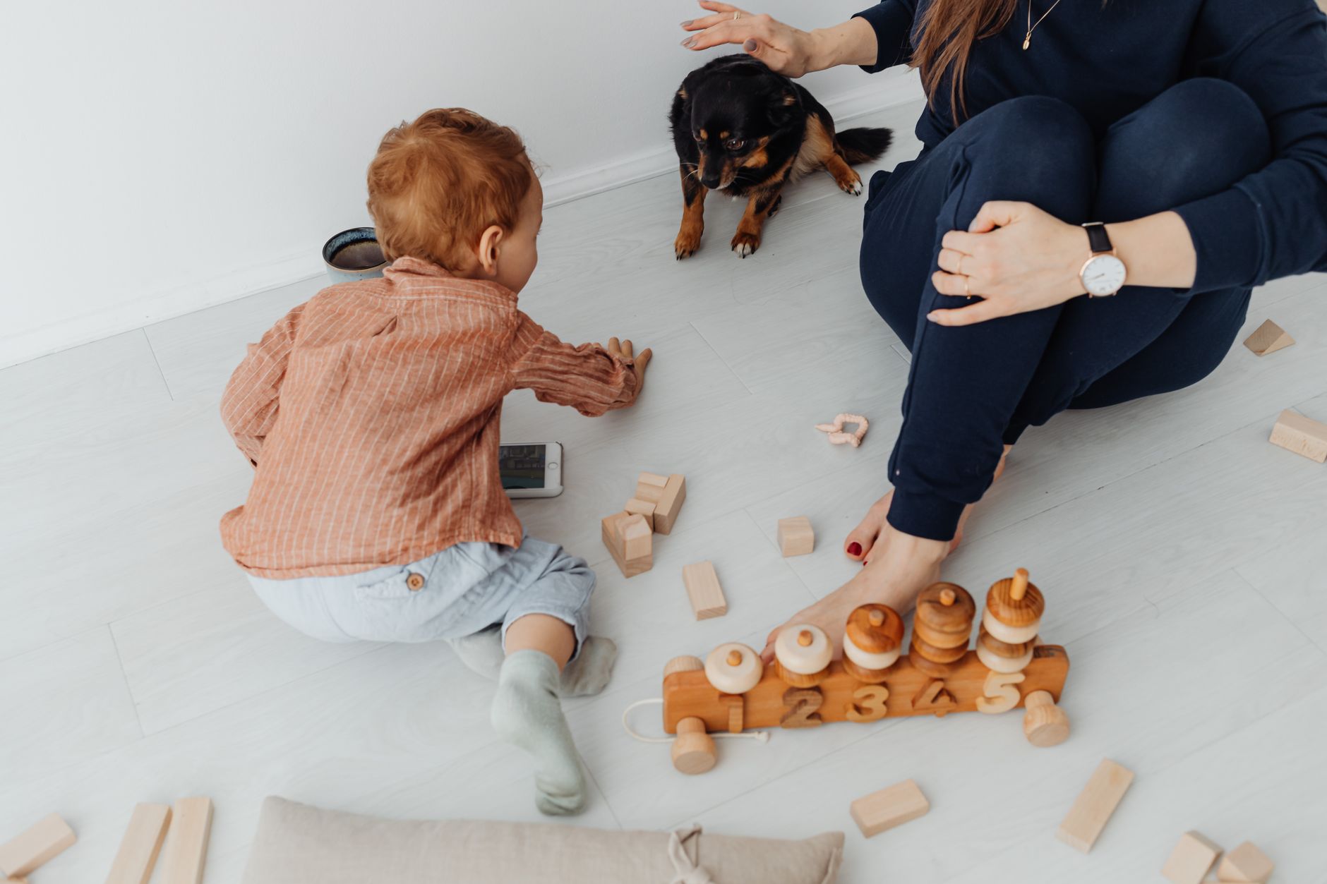 Toddler building blocks with parent watching