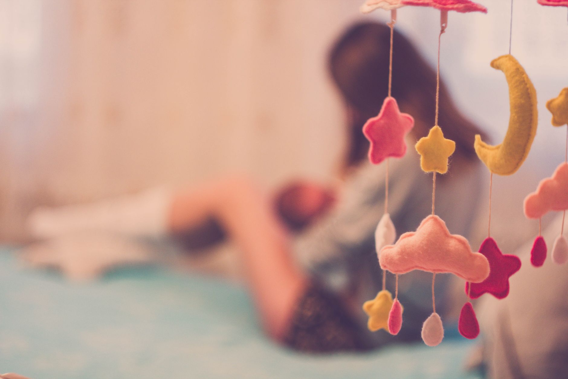 A nighttime nursing scene with a mother seated in a rocking chair, a soft lamp casting a gentle glow, and a baby wrapped in a light blanket, creating a calm feeding environment