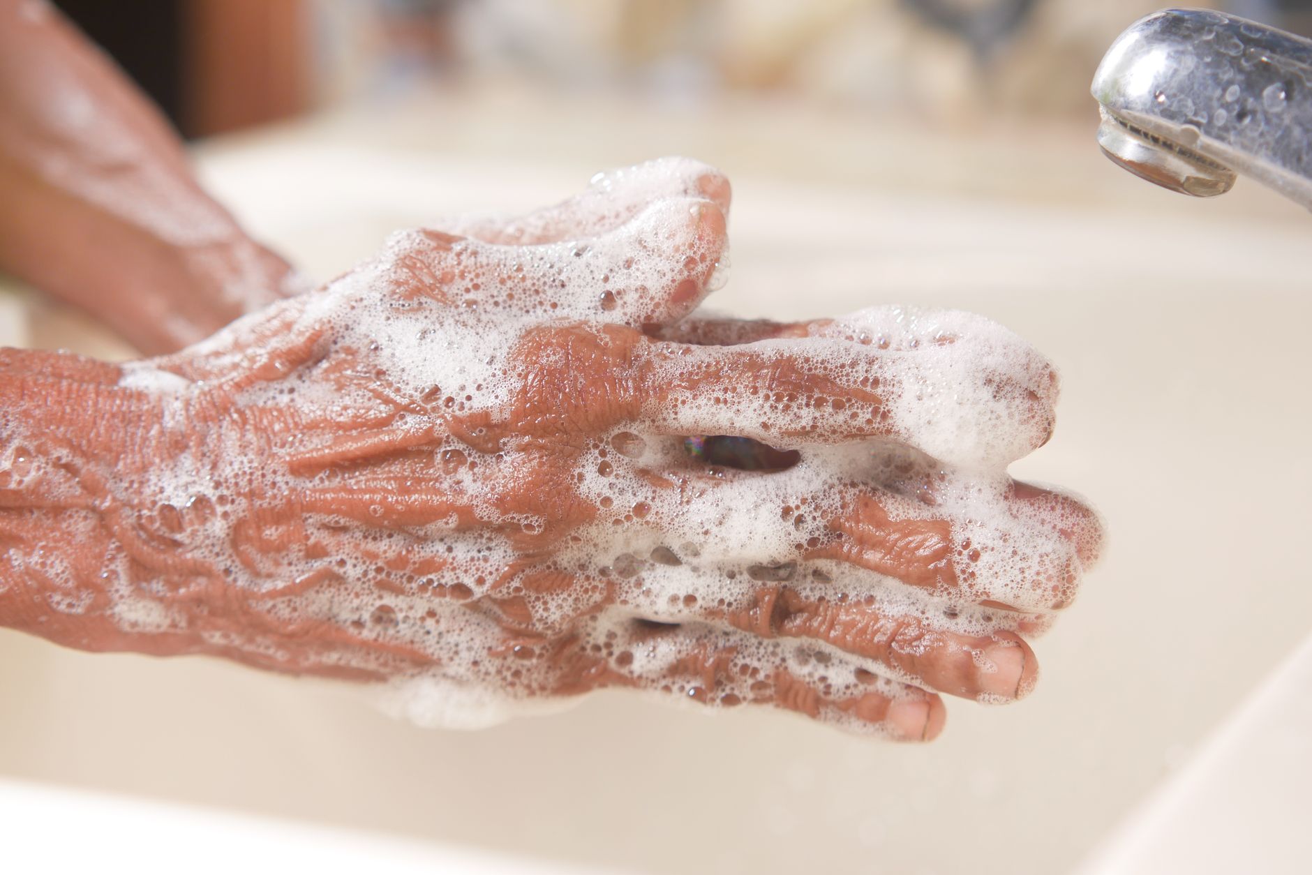 Close-up of hands thoroughly washing with soap and water, illustrating proper hygiene.