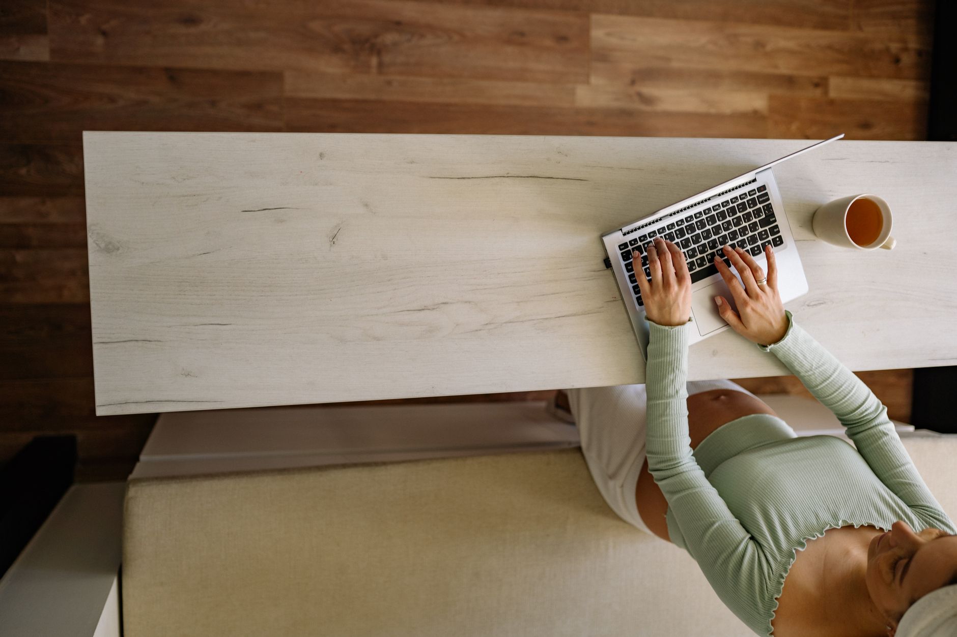 Young mother balancing work and pregnancy at a home desk