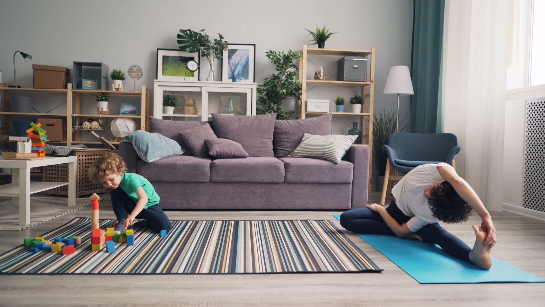 A mom practicing yoga with her child nearby
