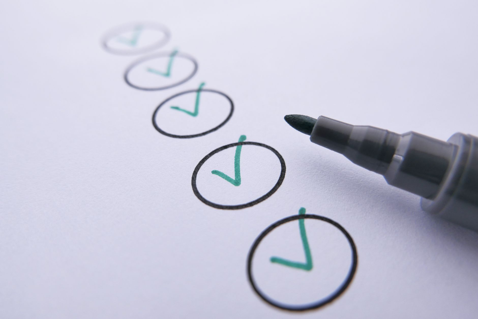 Close‑up of a neonatal assessment checklist with the Thompson score items highlighted, showing a clinician’s hand holding a pen
