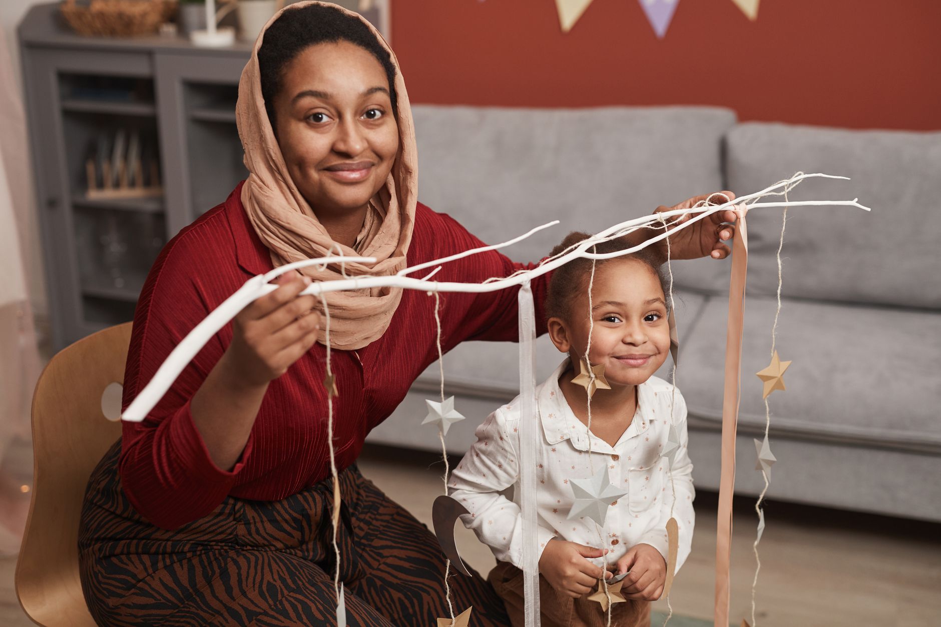 A mother and child decorating a Christmas tree together.