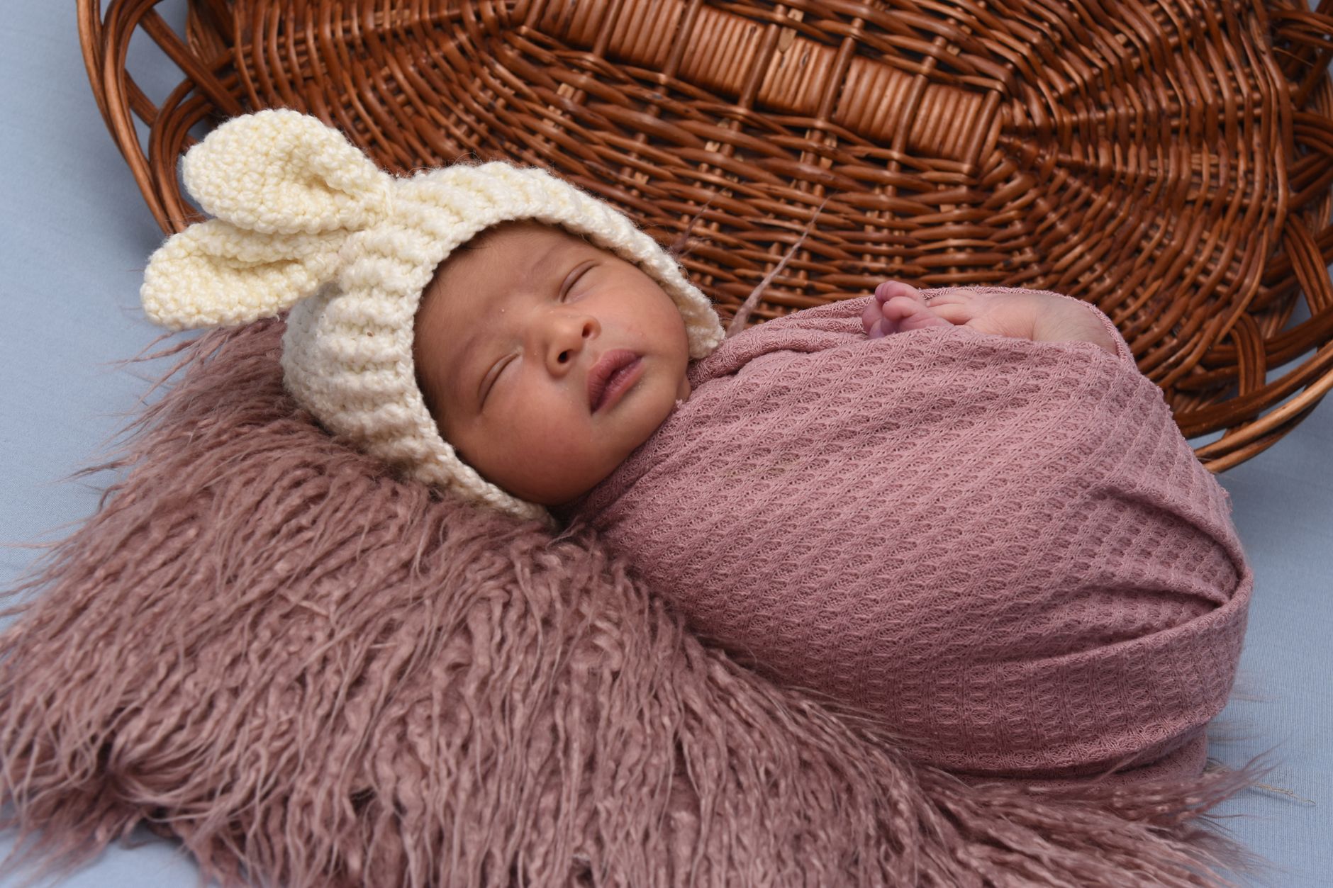 Newborn baby swaddled in a soft blanket, wearing a tiny hat