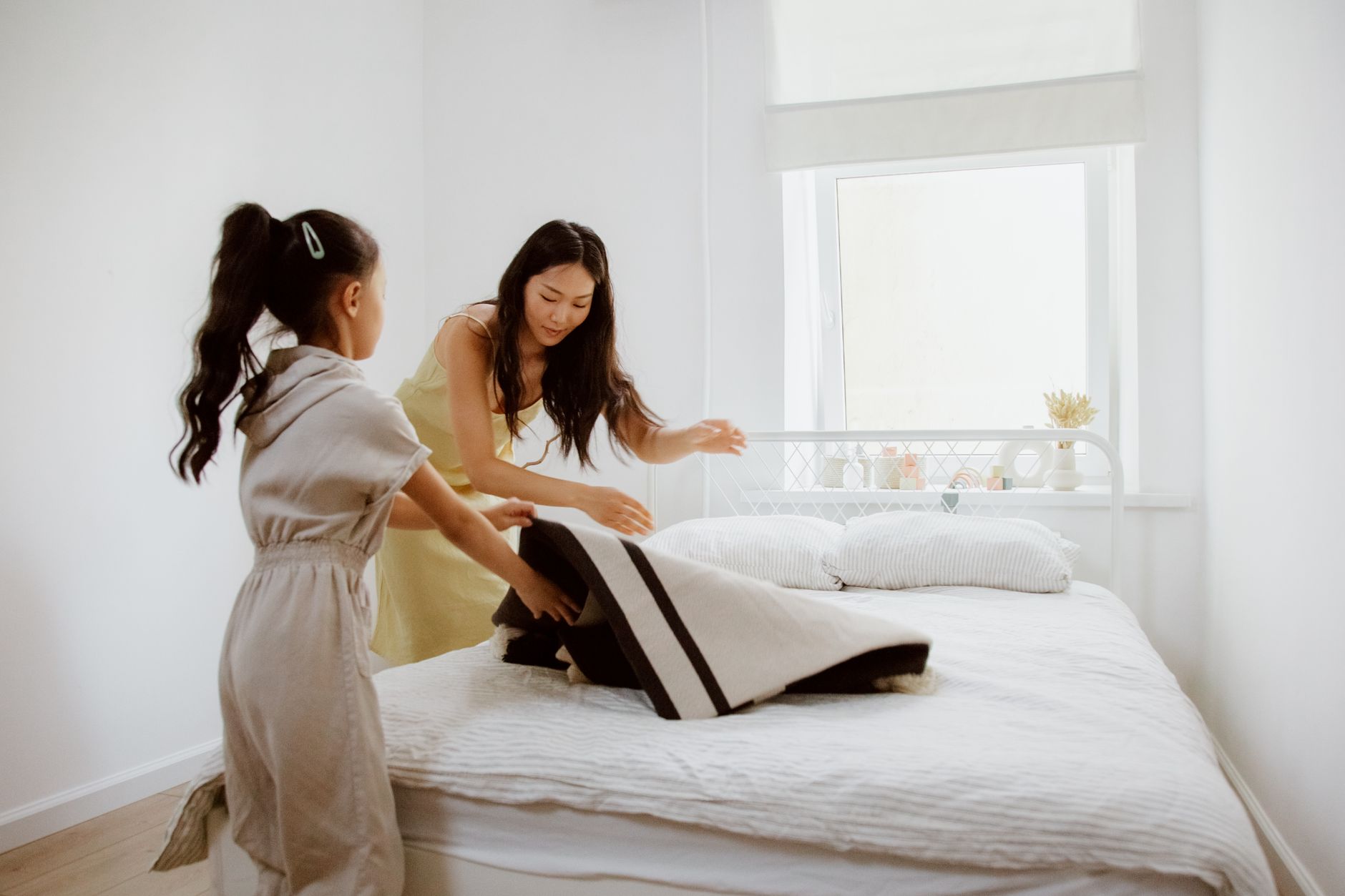 A family sitting together at the kitchen table with a printed chore chart and sticky notes, collaborating on household tasks