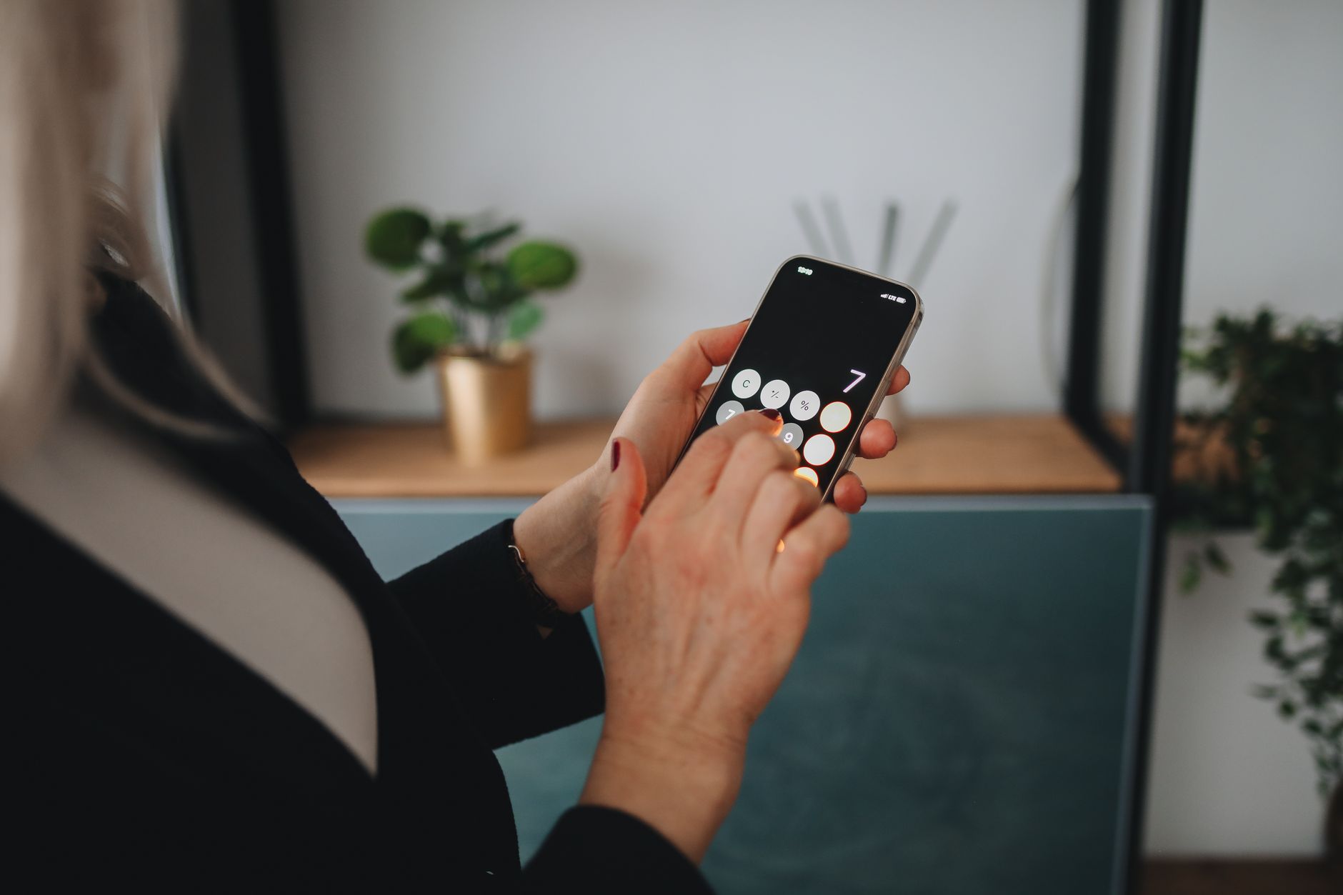 A woman holding a smartphone with a pregnancy app open, showing a due date calculation