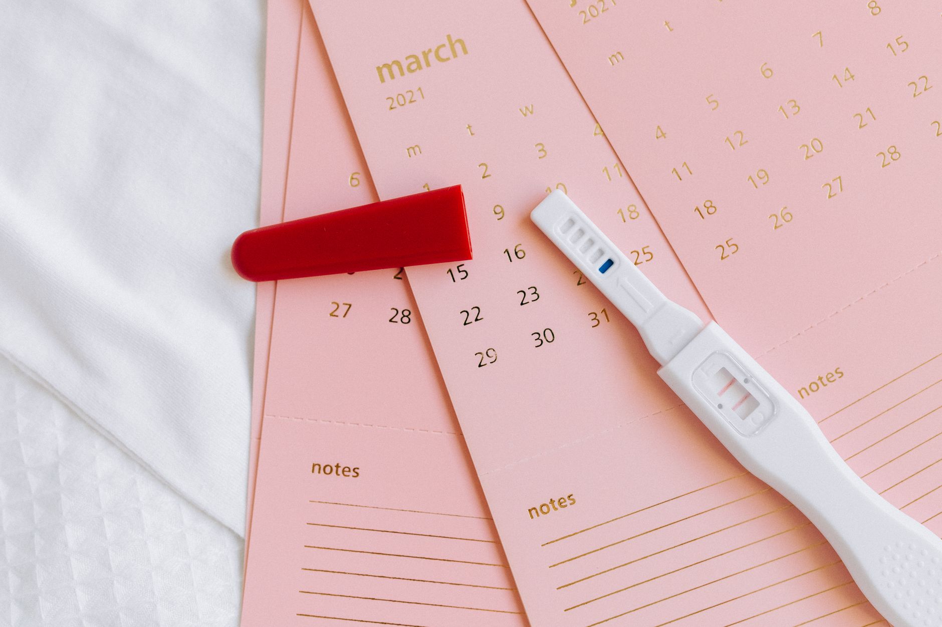 A close-up of a positive pregnancy test with a '2-3 weeks' estimate displayed on the screen