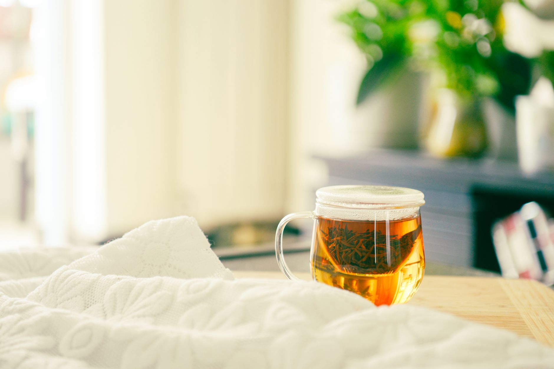 A pregnant woman resting on a comfortable sofa with a warm blanket, a cup of herbal tea on a nearby table, soft natural light