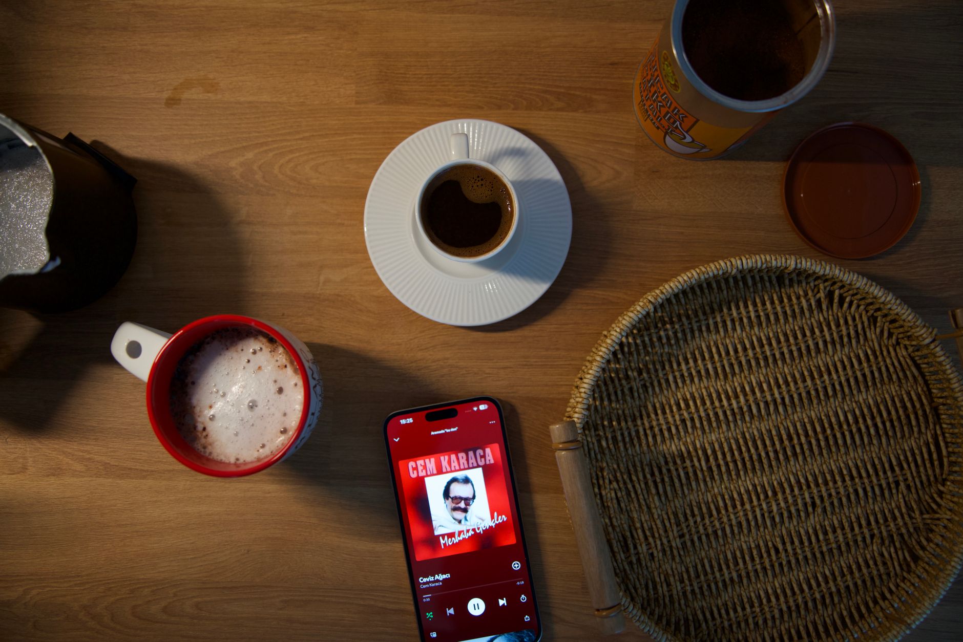 A tidy kitchen counter with a baby diary, a smartphone displaying a diaper‑tracking app, and a cup of tea, illustrating a calm morning routine for new parents