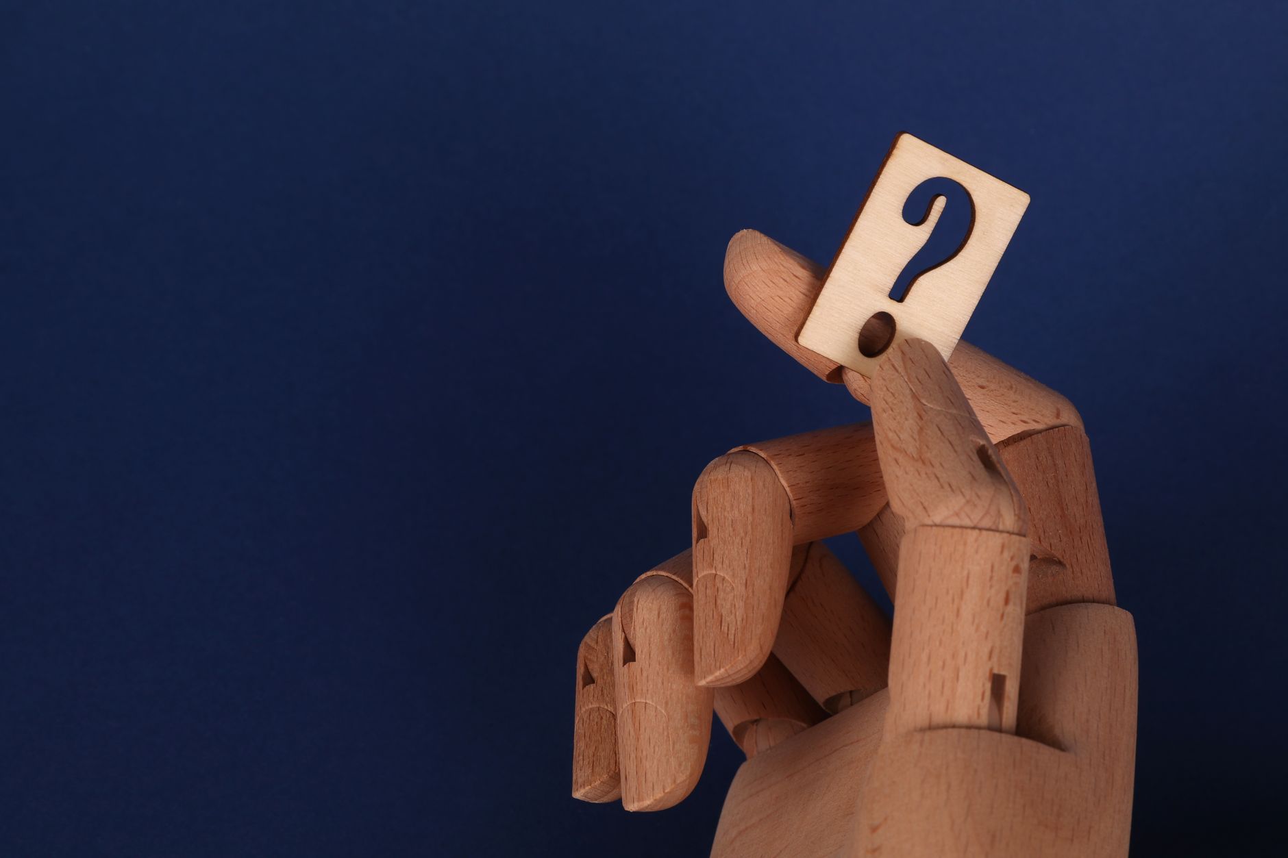 Pregnant woman holding a baby block with a question mark, symbolizing uncertainty about fetal weight