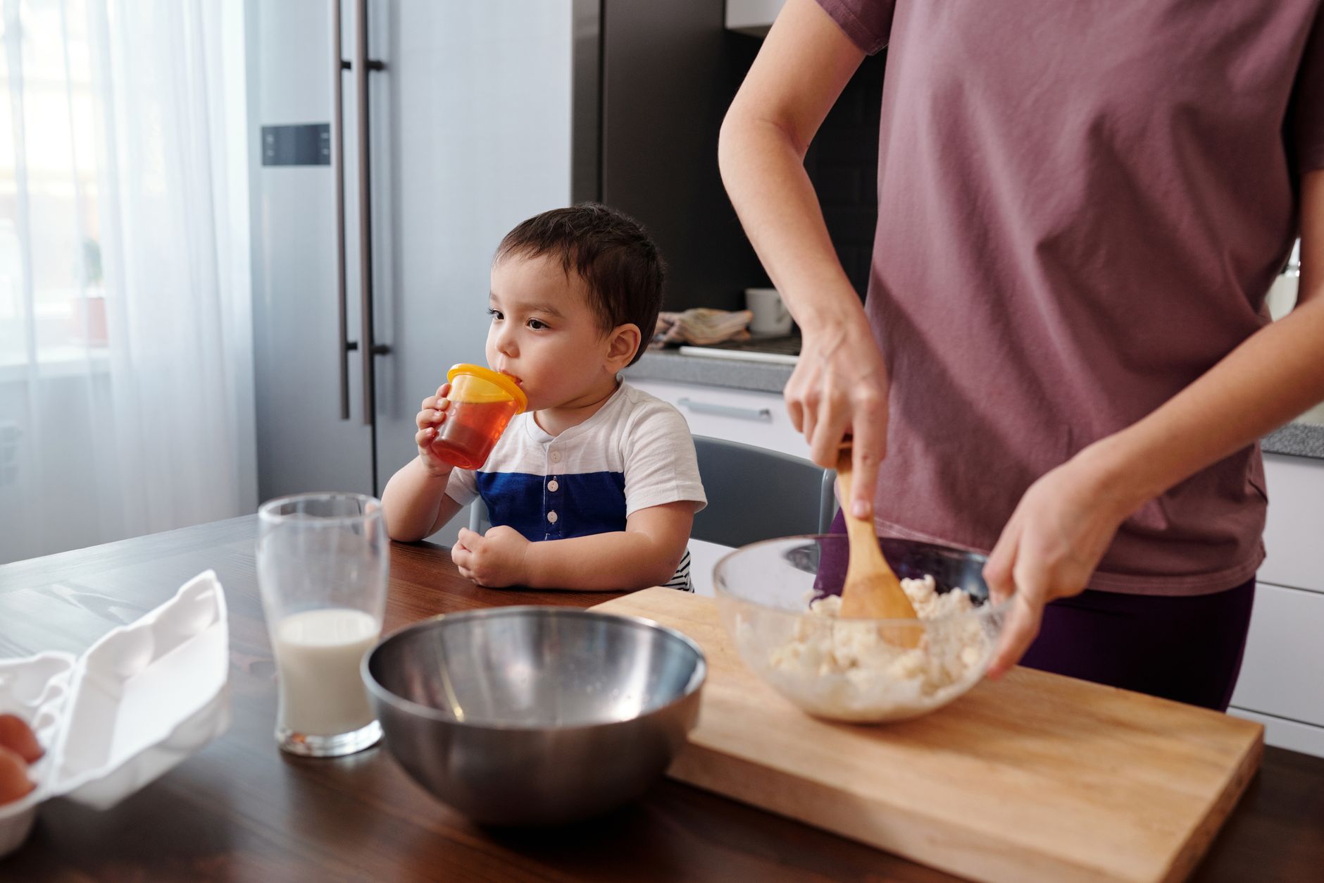 Toddler drinking from sippy cup with solid foods