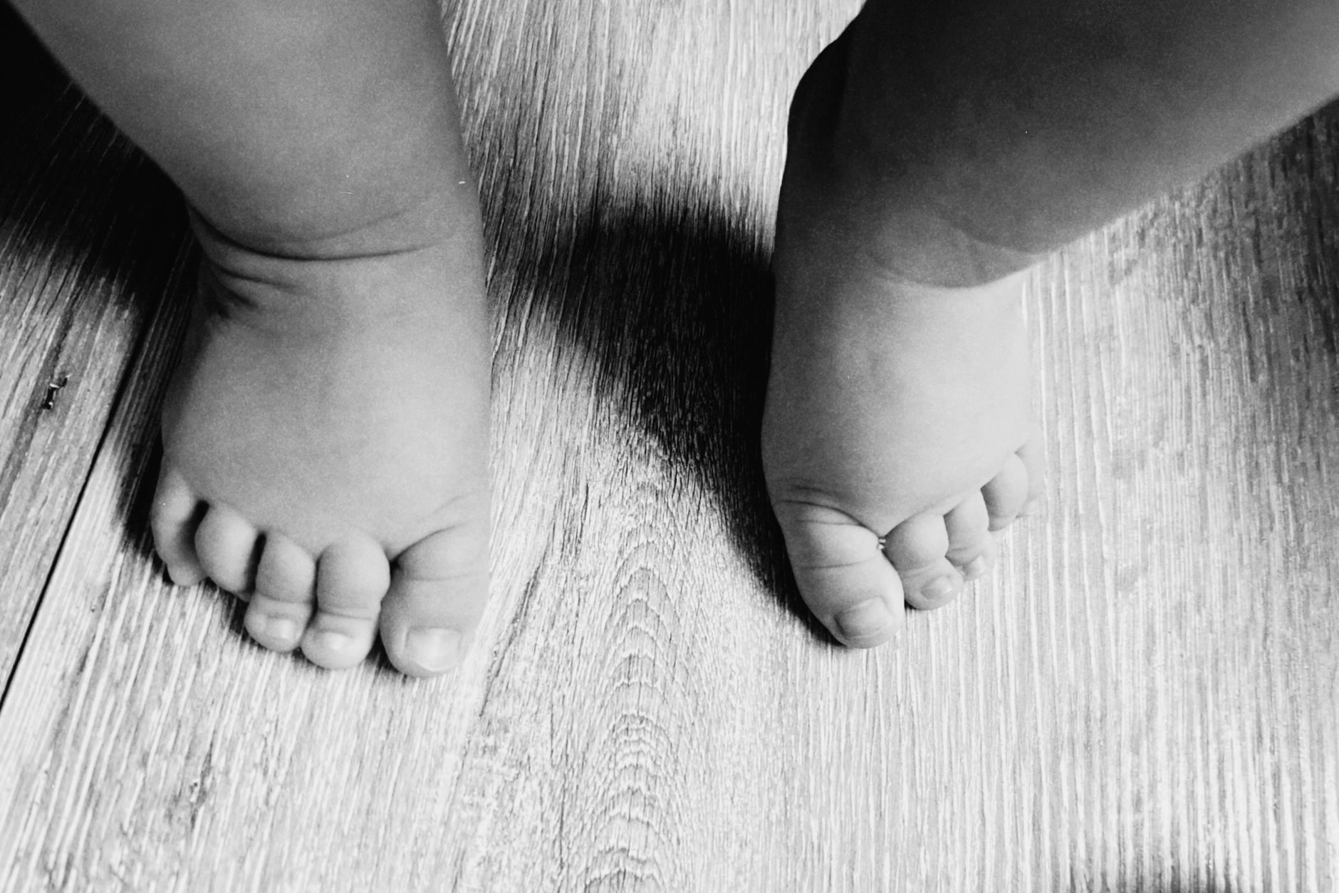 A baby's feet playfully kicking while lying on a soft blanket, indicating alertness and activity.
