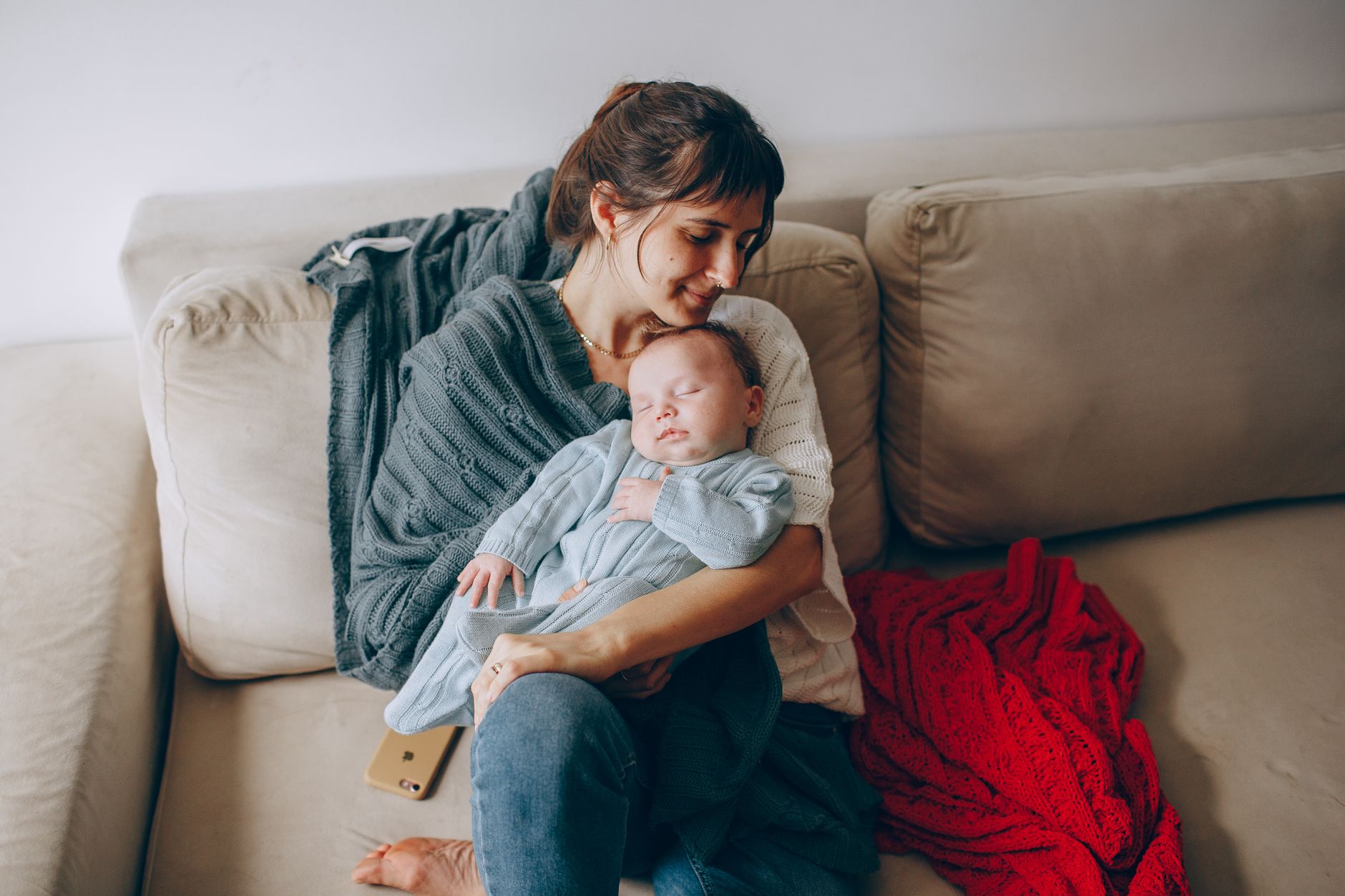 Parent burping a baby over their shoulder, baby's head supported