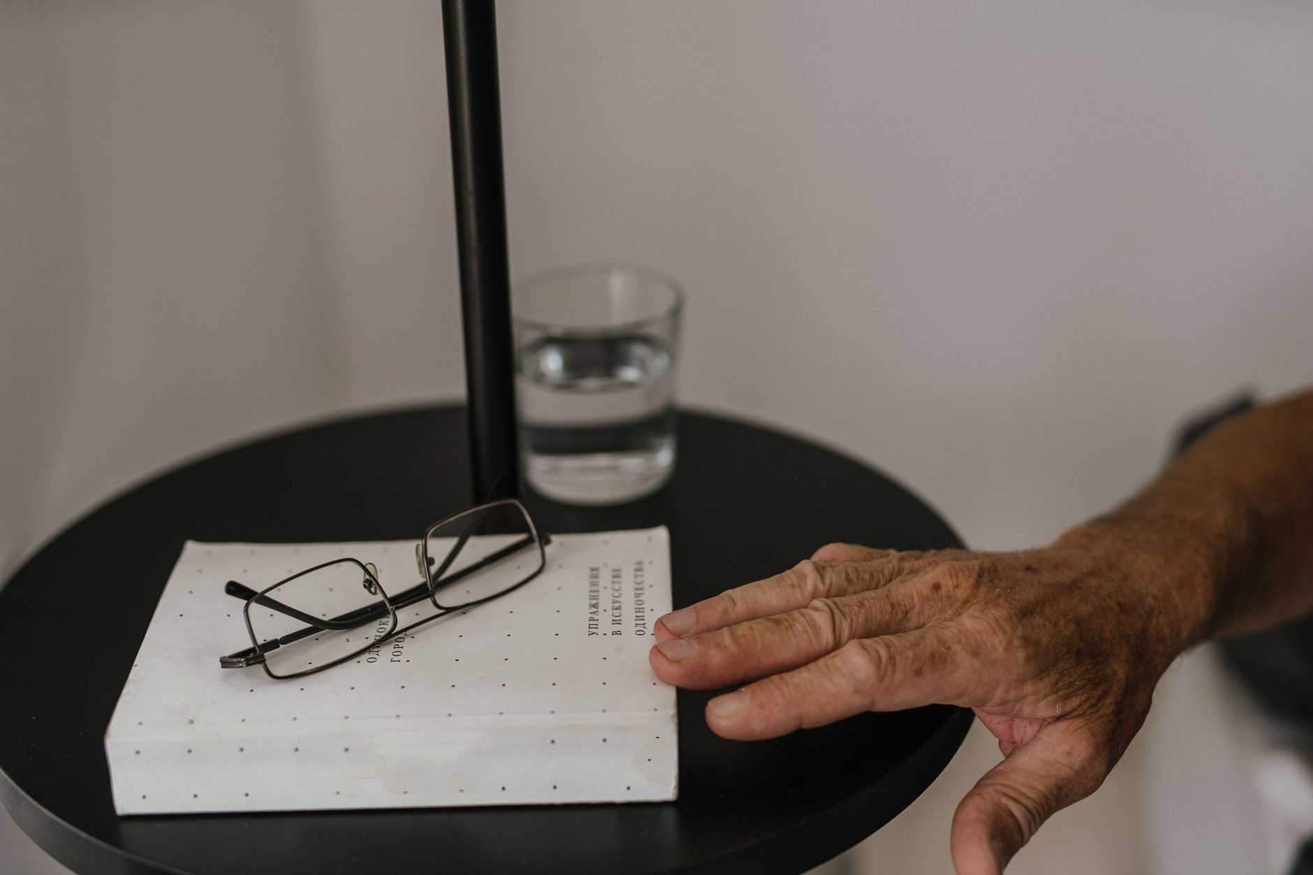 A woman's hand holding a glass of water, symbolizing hydration and self-care