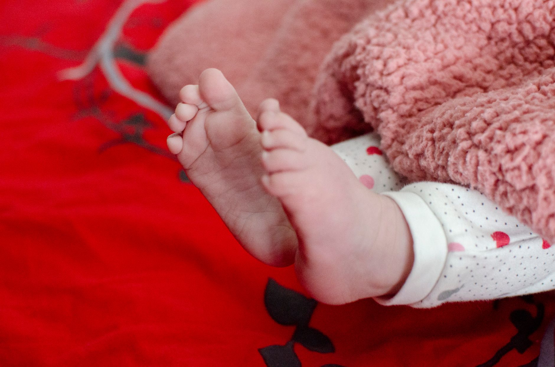 Baby's feet under blanket with vitamin D bottle