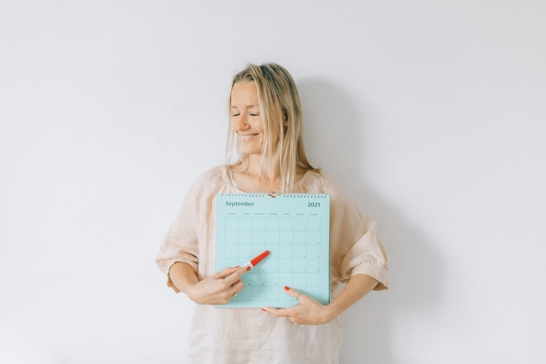 Woman checking a calendar after a positive pregnancy test