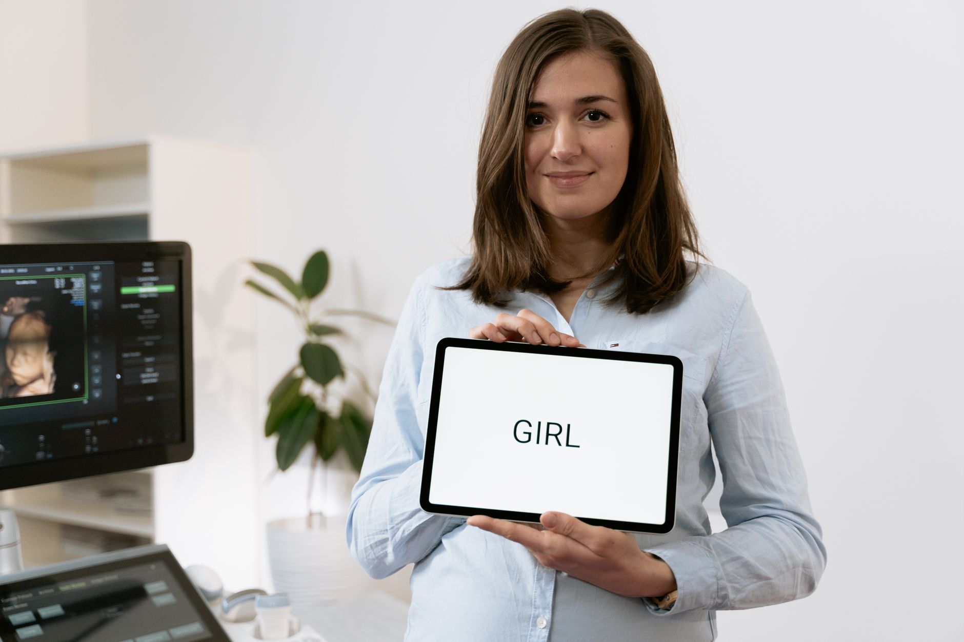 A doctor and a pregnant woman reviewing ultrasound images on a tablet, with a calm and reassuring atmosphere
