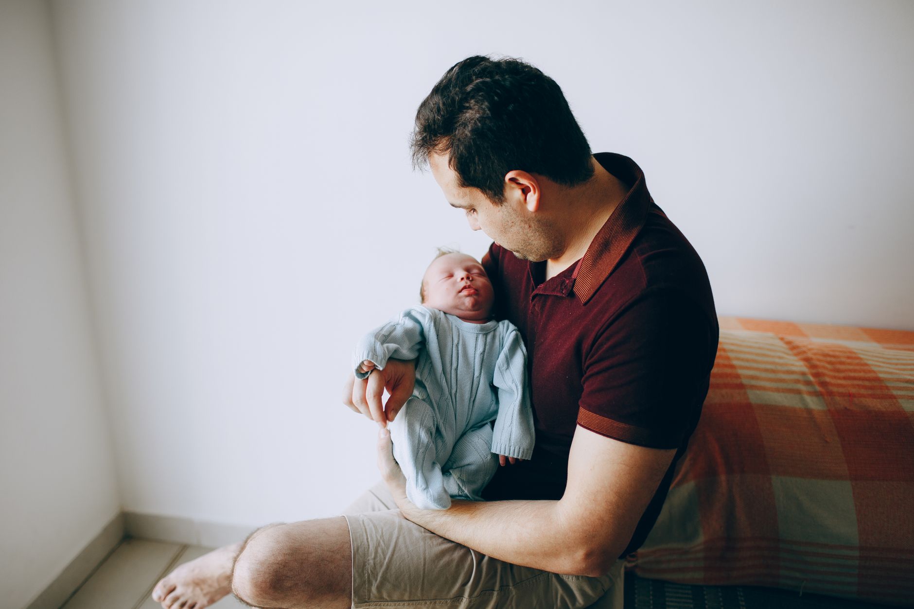 A dad laughing as he holds his newborn for the first time
