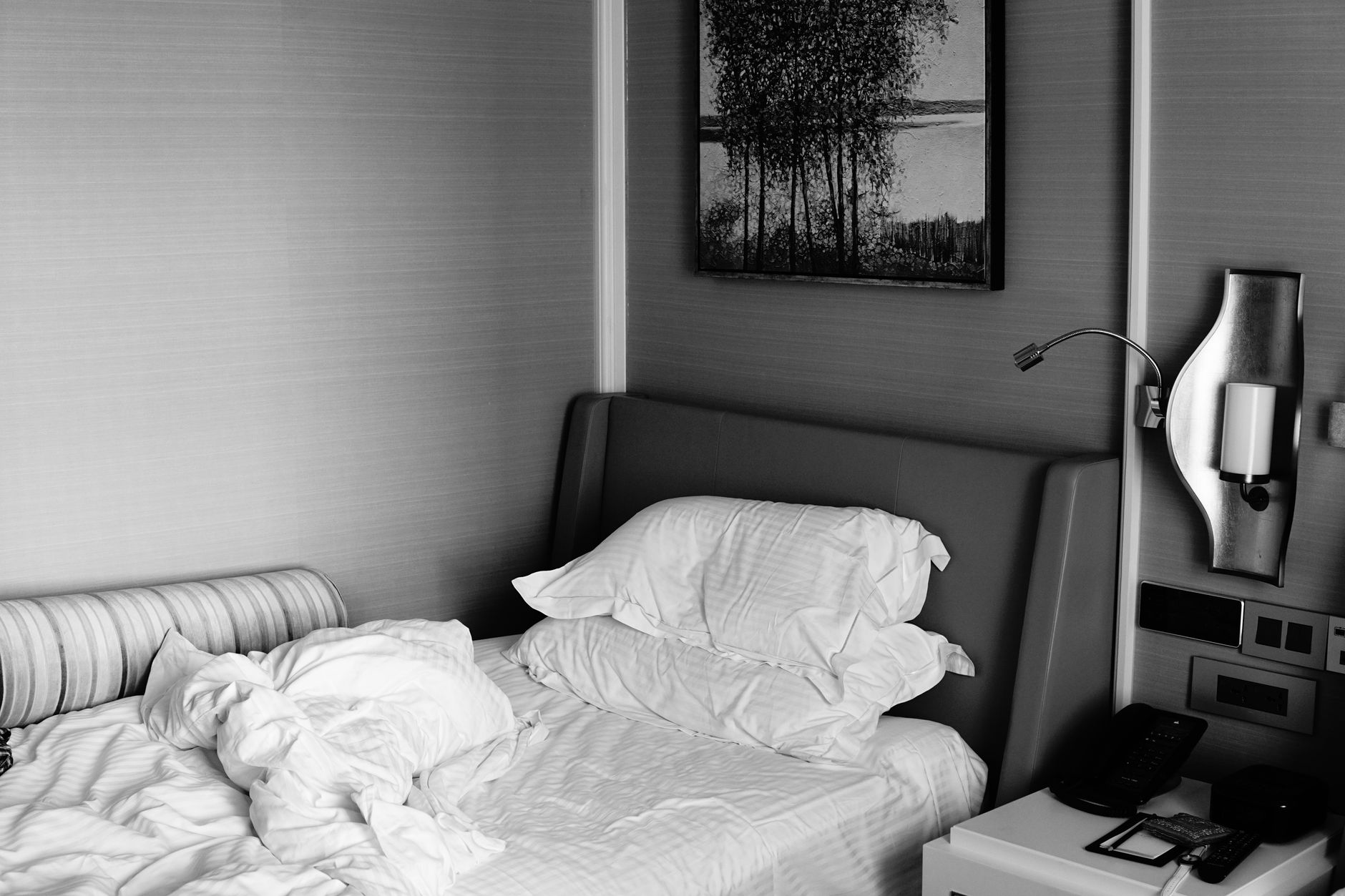 Soft‑focused image of a hospital room with a bedside table holding a glass of water, a small bowl of crackers, and a phone, natural light through a window, calm and clean setting