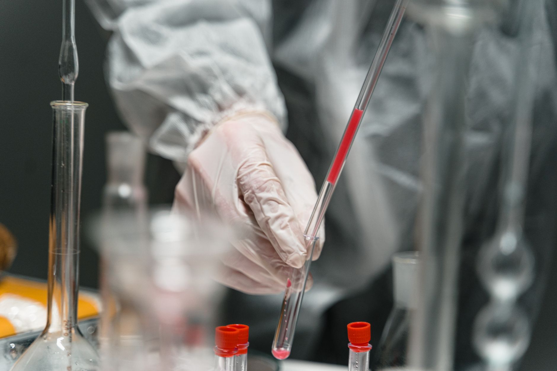 Close‑up of a lab technician holding a test tube with bright liquid, representing blood work for electrolyte testing, clean clinical environment
