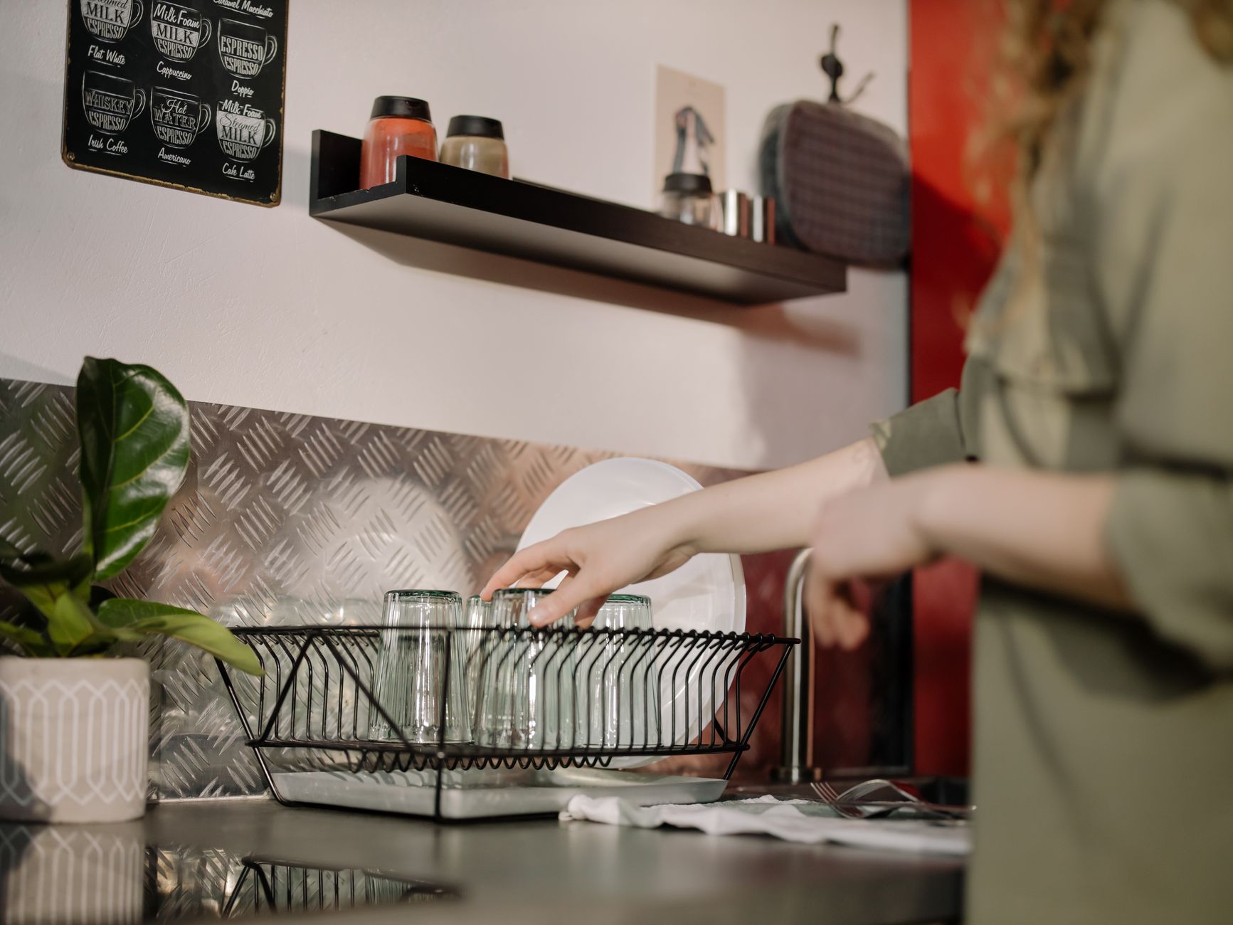 A woman's hands assembling the various parts of a breast pump on a clean kitchen counter.