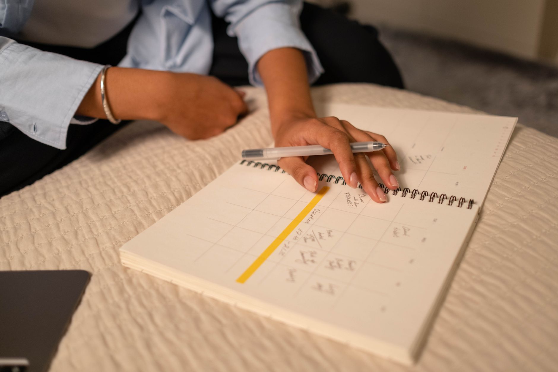 A person making a phone call, with a calendar and notepad visible, for insurance follow-up.