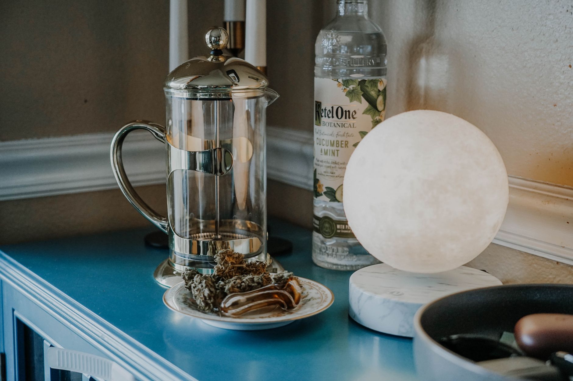 A cozy kitchen scene with a bottle of herbal tea, a glass of water, and a baby bottle, symbolizing the need for caution with herbal drinks while breastfeeding