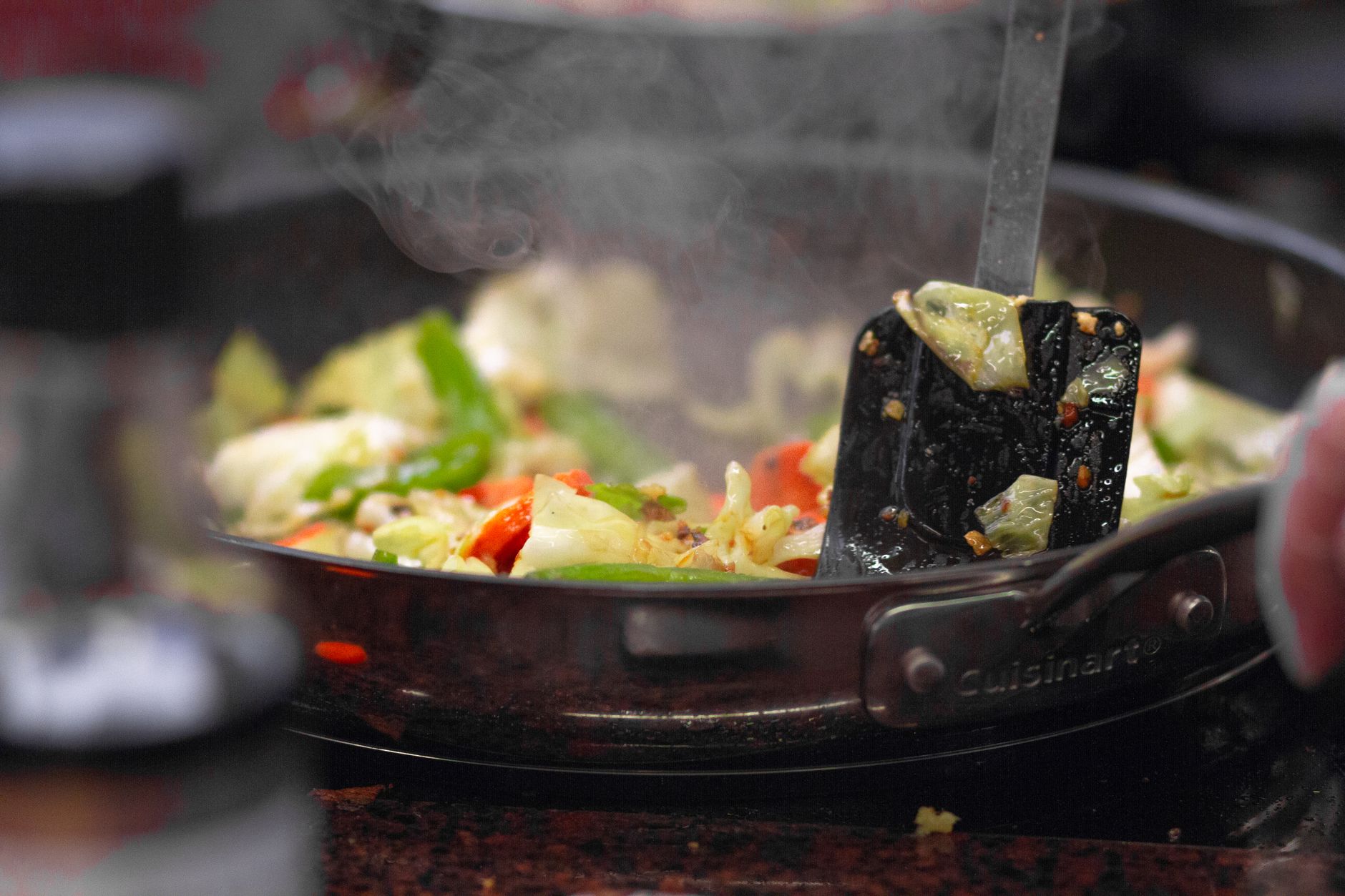 A skillet with fully cooked andouille sausage slices sizzling alongside colorful bell peppers, demonstrating a balanced, pregnancy‑safe meal
