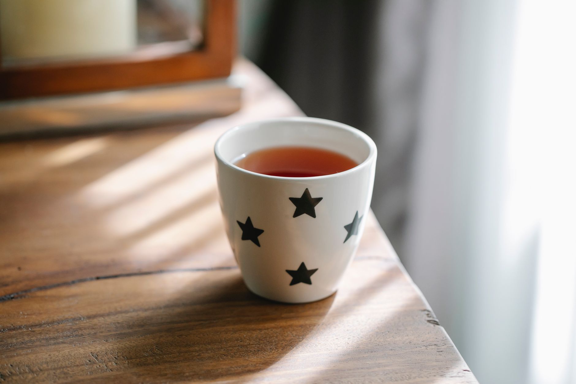 A steaming mug of ginger tea beside a small glass of diluted apple cider vinegar, illustrating a gentle alternative for morning sickness.