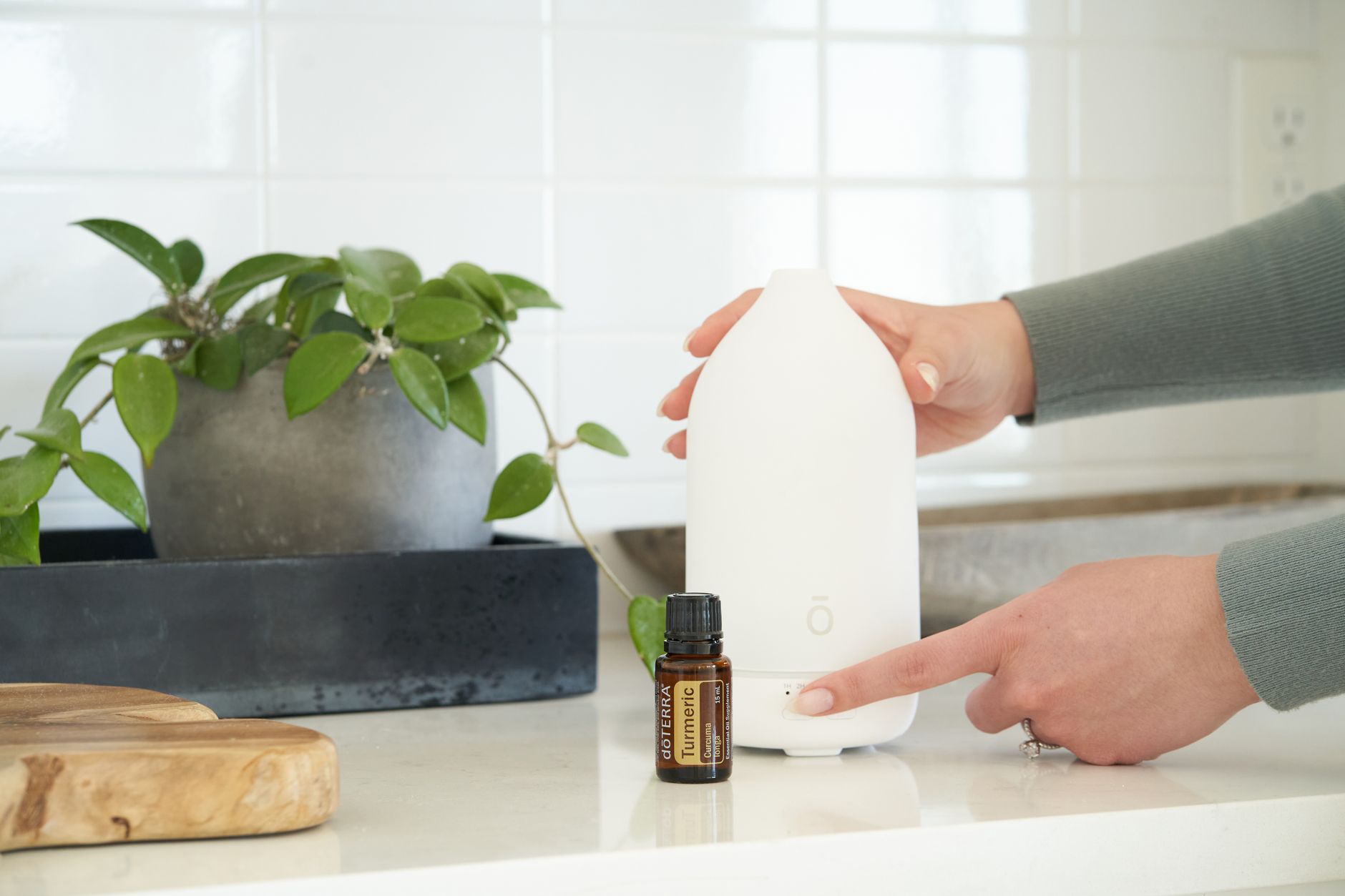 A clear glass bottle of peppermint essential oil beside a small ceramic diffuser, illustrating a calming, low‑dose setup for pregnant women seeking nausea relief