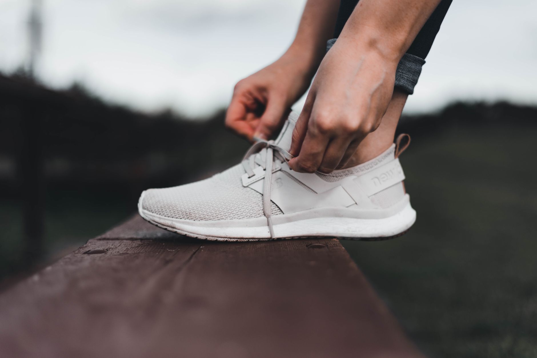 Close-up of a pregnant woman’s hands adjusting bowling shoes with non-slip soles