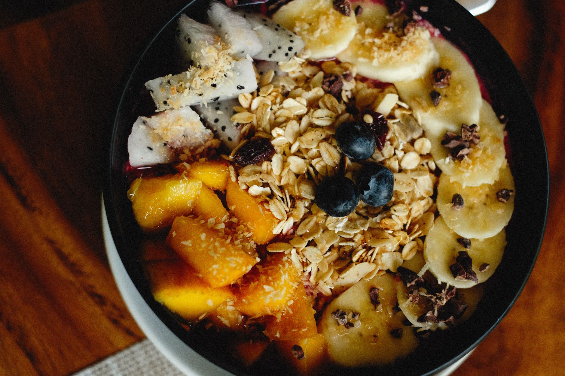 A bright morning smoothie bowl featuring cacao powder, sliced banana, berries, and a sprinkle of cinnamon, representing a balanced pregnancy snack