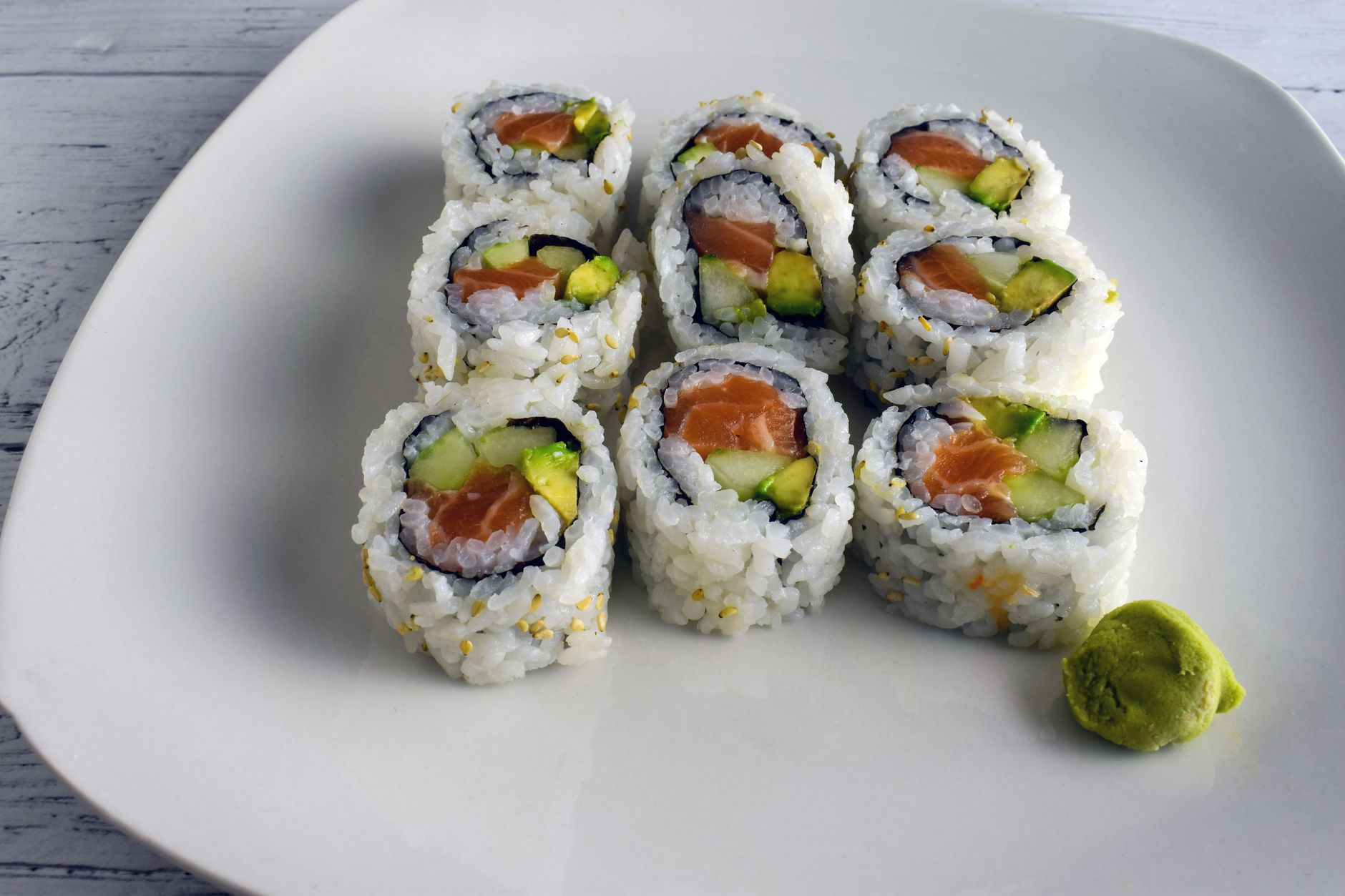 assortment of sushi rolls on a platter, highlighting cooked shrimp, avocado, and vegetable rolls as pregnancy‑friendly options, bright natural lighting