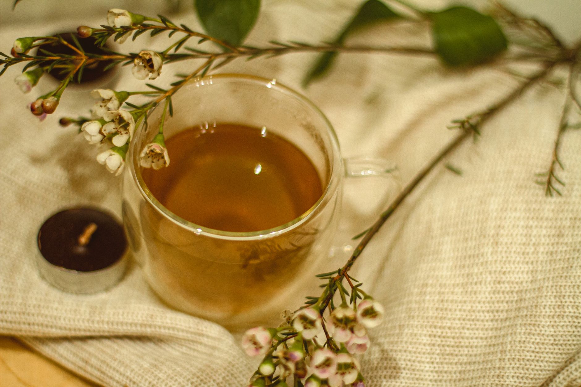 A selection of herbal teas and a hot water bottle on a bedside table, creating a comforting, pregnancy-safe setup.