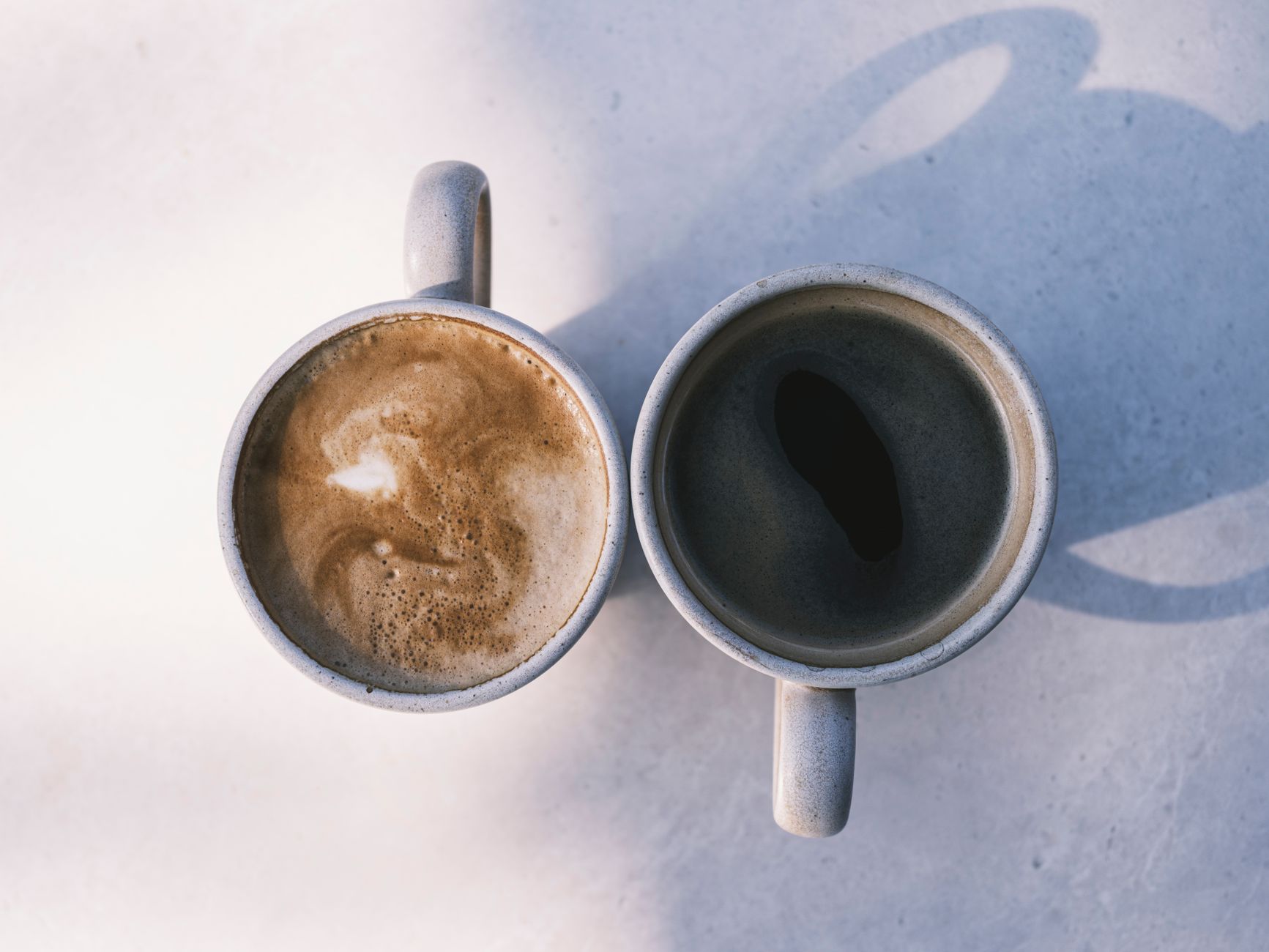 A side‑by‑side comparison of a traditional chai latte and a decaf rooibos latte, both in clear glass mugs, illustrating the color and froth differences