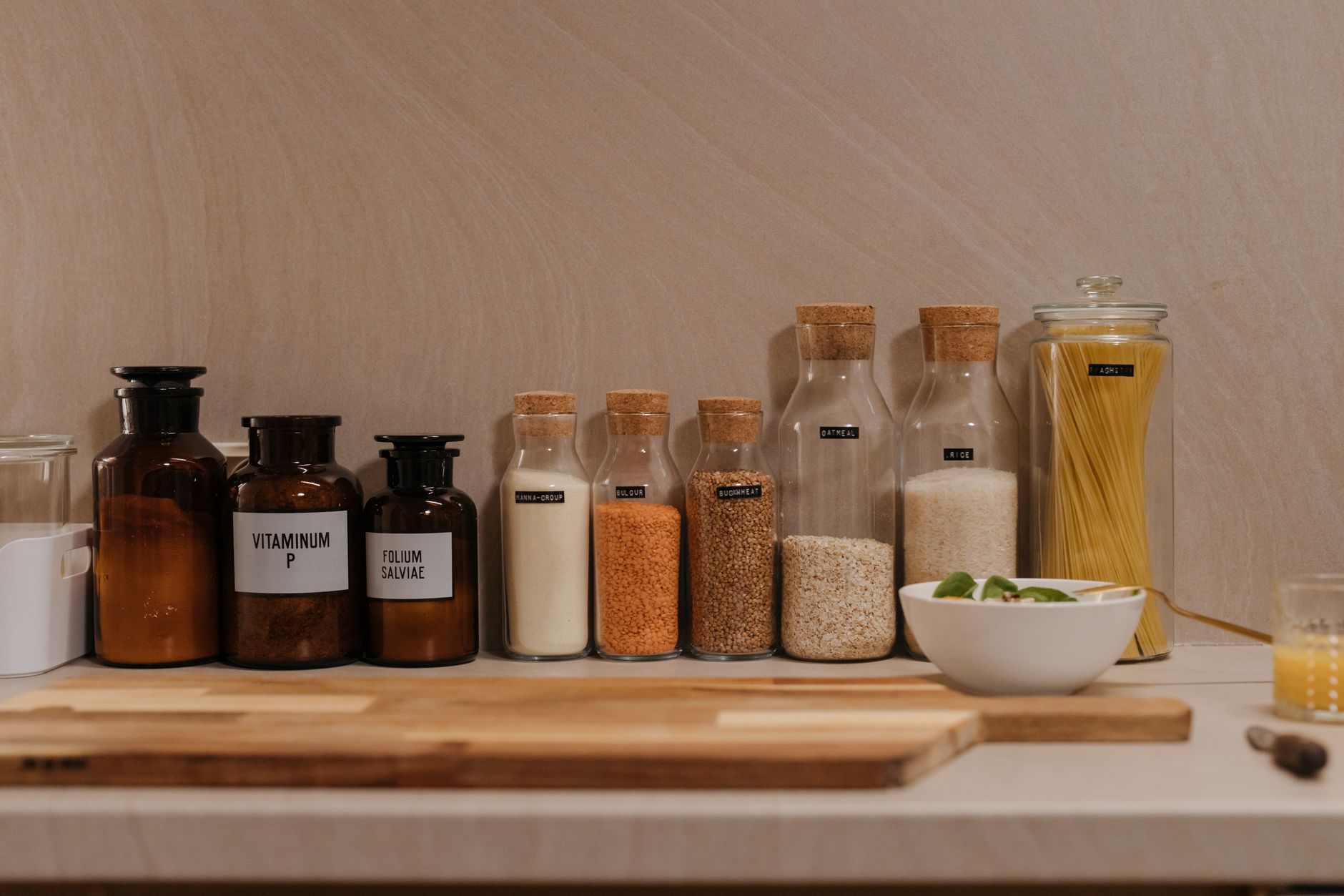 A tidy pantry shelf displaying a row of chlorella supplement bottles alongside prenatal vitamins, illustrating how to store supplements safely and keep them organized for easy daily routine.