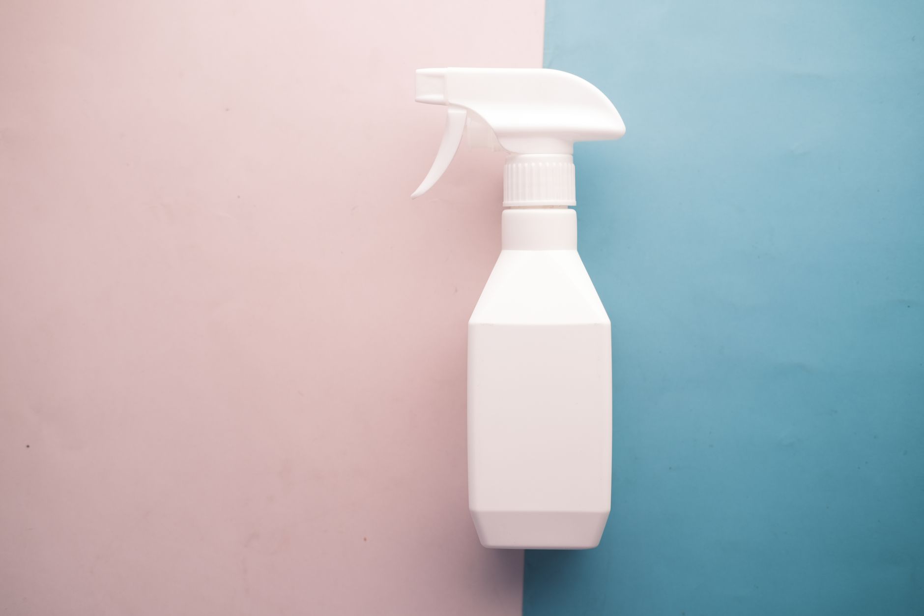 a hand holding a saline nasal spray bottle against a soft pastel background, illustrating a gentle, pregnancy‑safe alternative to decongestants