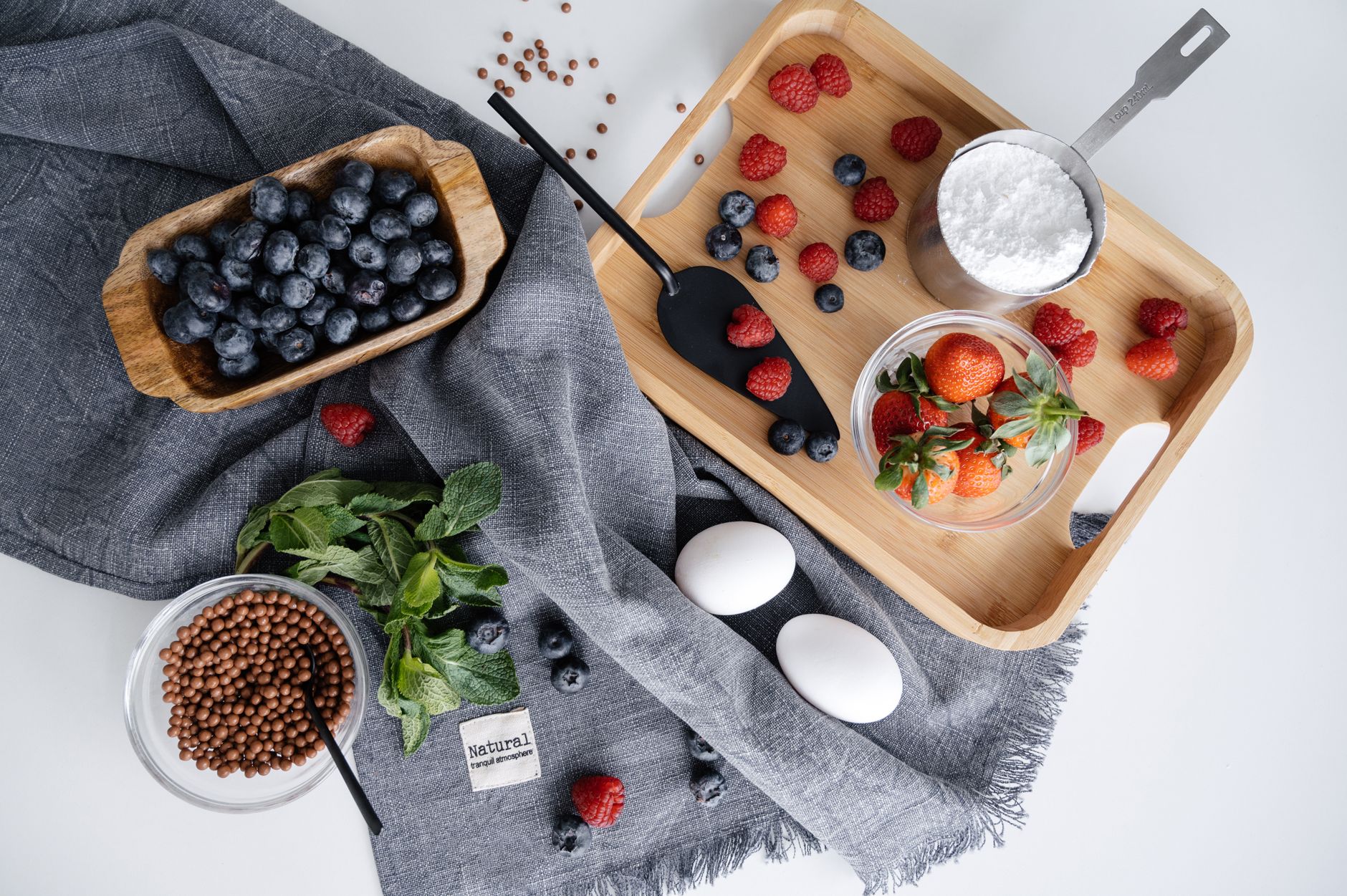 A neatly arranged breakfast plate featuring a bowl of bone broth, a scoop of collagen powder, and fresh berries, illustrating natural sources of collagen‑supporting nutrients