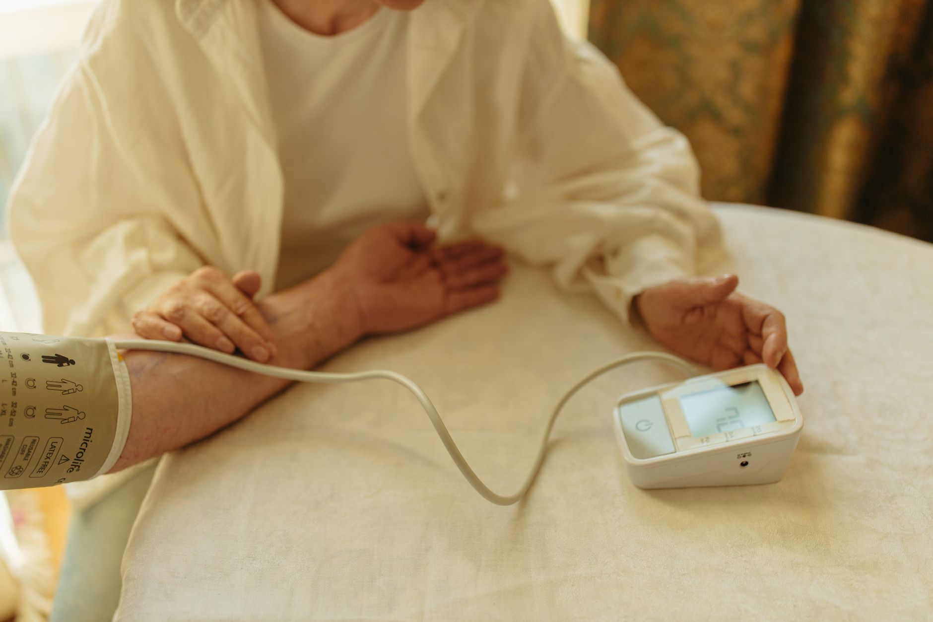 pregnant woman monitoring her blood pressure at home with a digital cuff