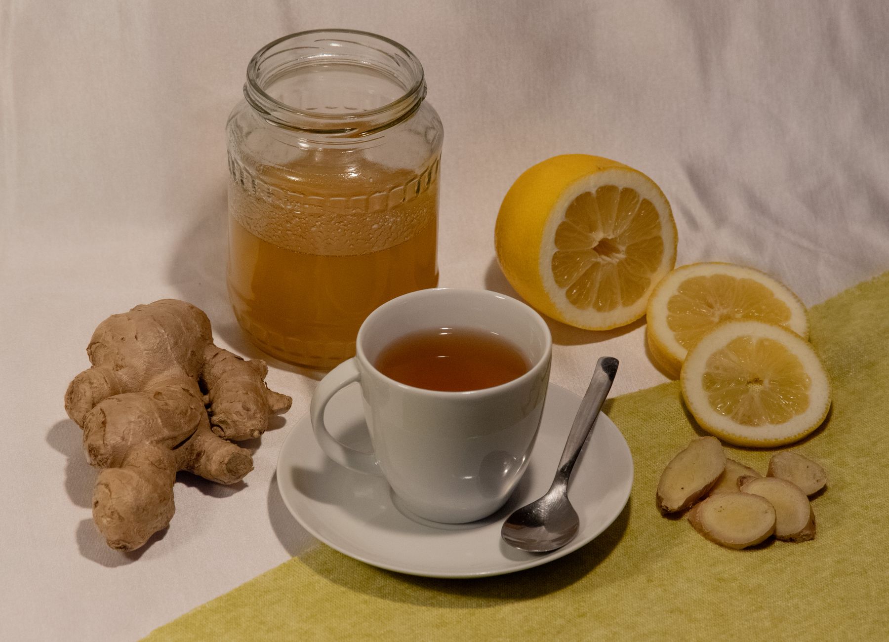 a cozy kitchen scene with a mug of warm lemon ginger tea, a jar of honey, and a box of Delsym on the counter, illustrating natural and OTC cough relief options for pregnant individuals