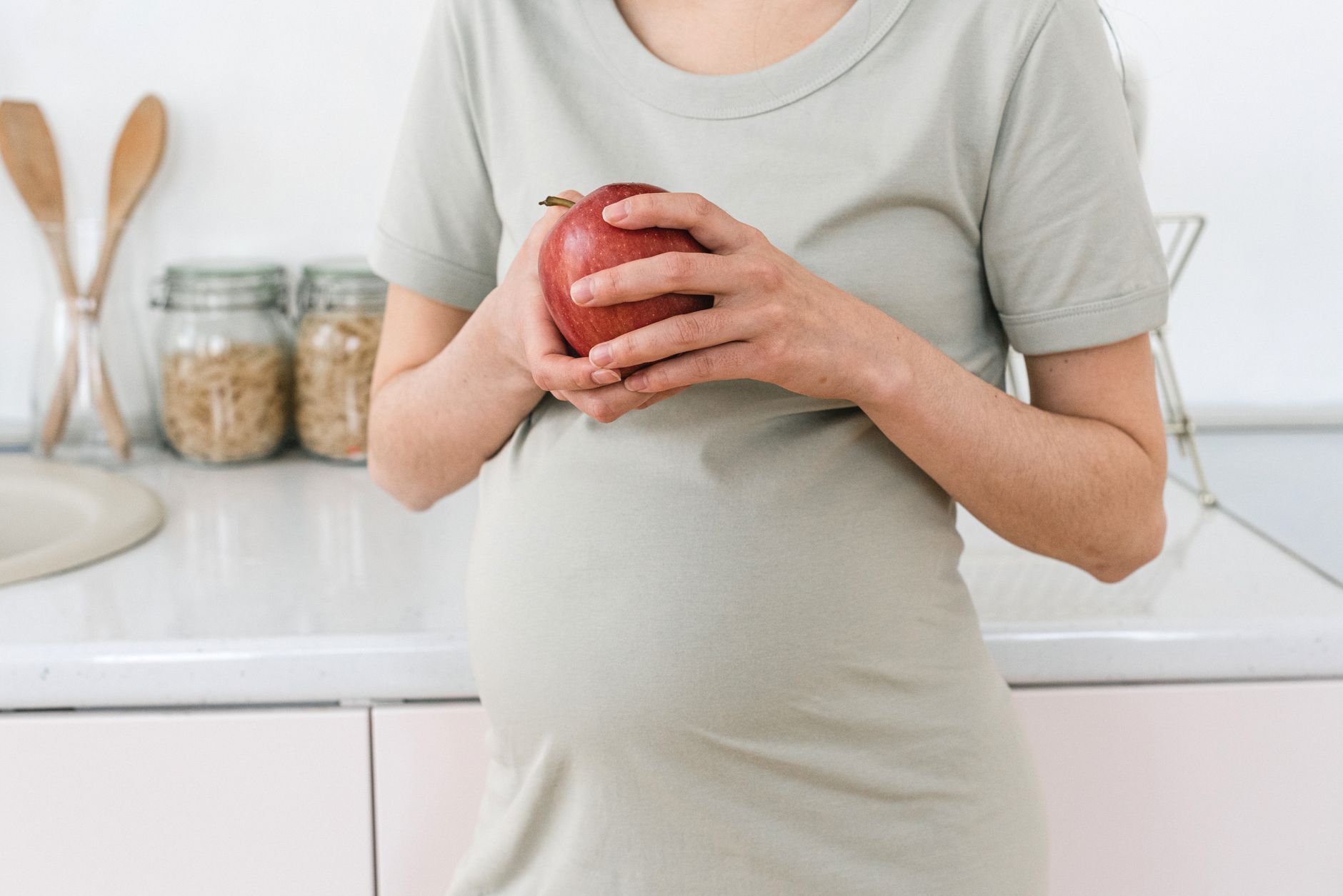 pregnant woman holding a prenatal vitamin bottle, soft morning light streaming through a window, emphasizing a calm, hopeful atmosphere