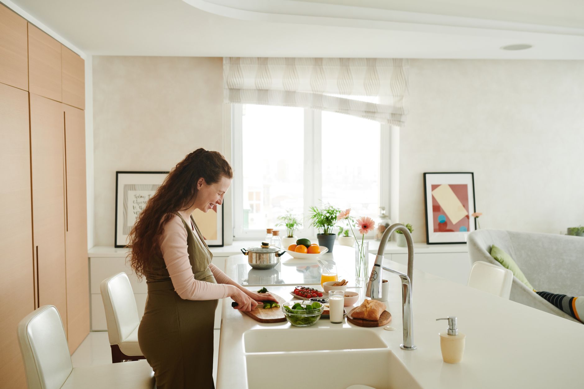 pregnant woman holding a plate of well-cooked steak and vegetables