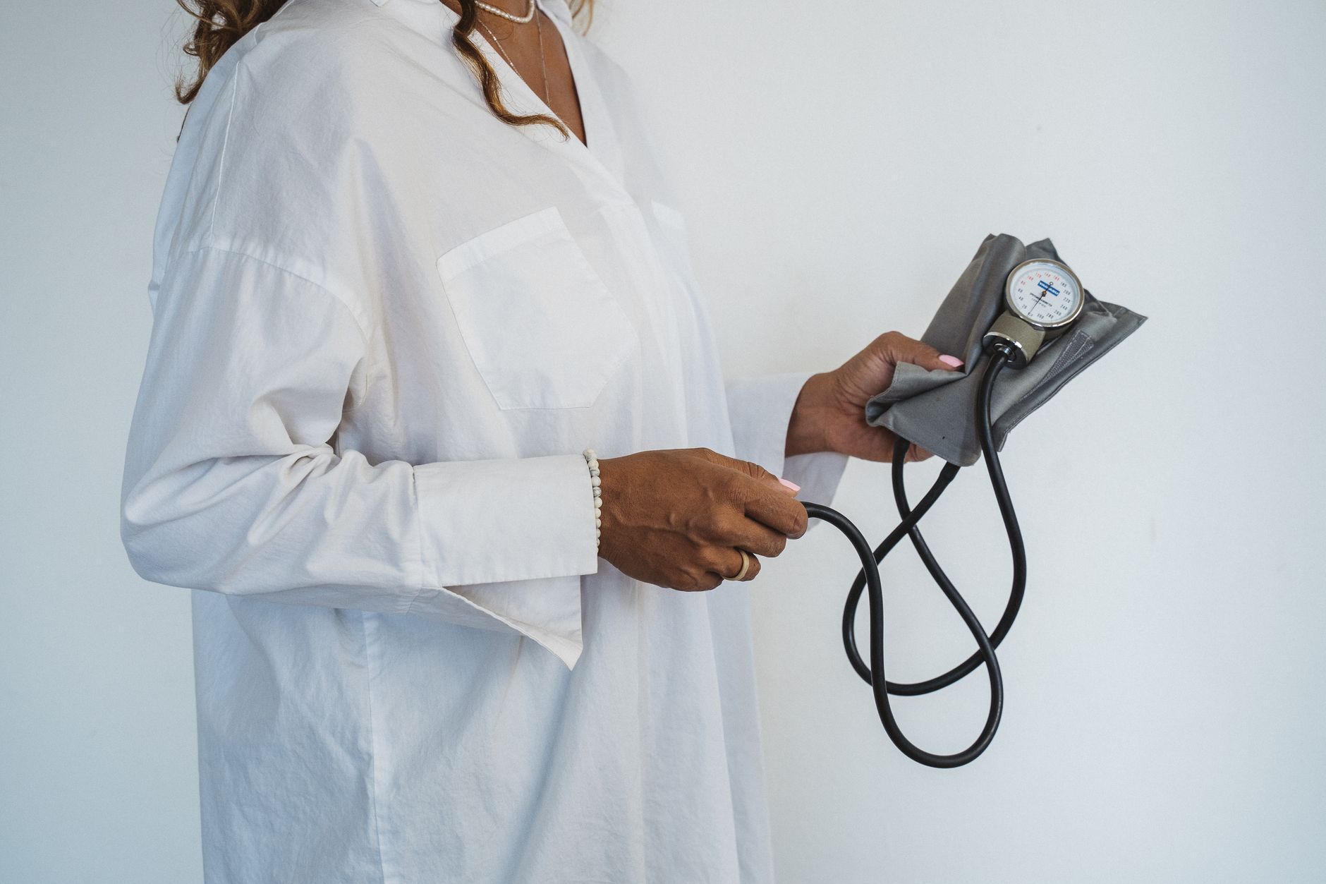 a stylized illustration of a pregnant woman holding a blood pressure cuff, a soft pastel background emphasizing calm and safety