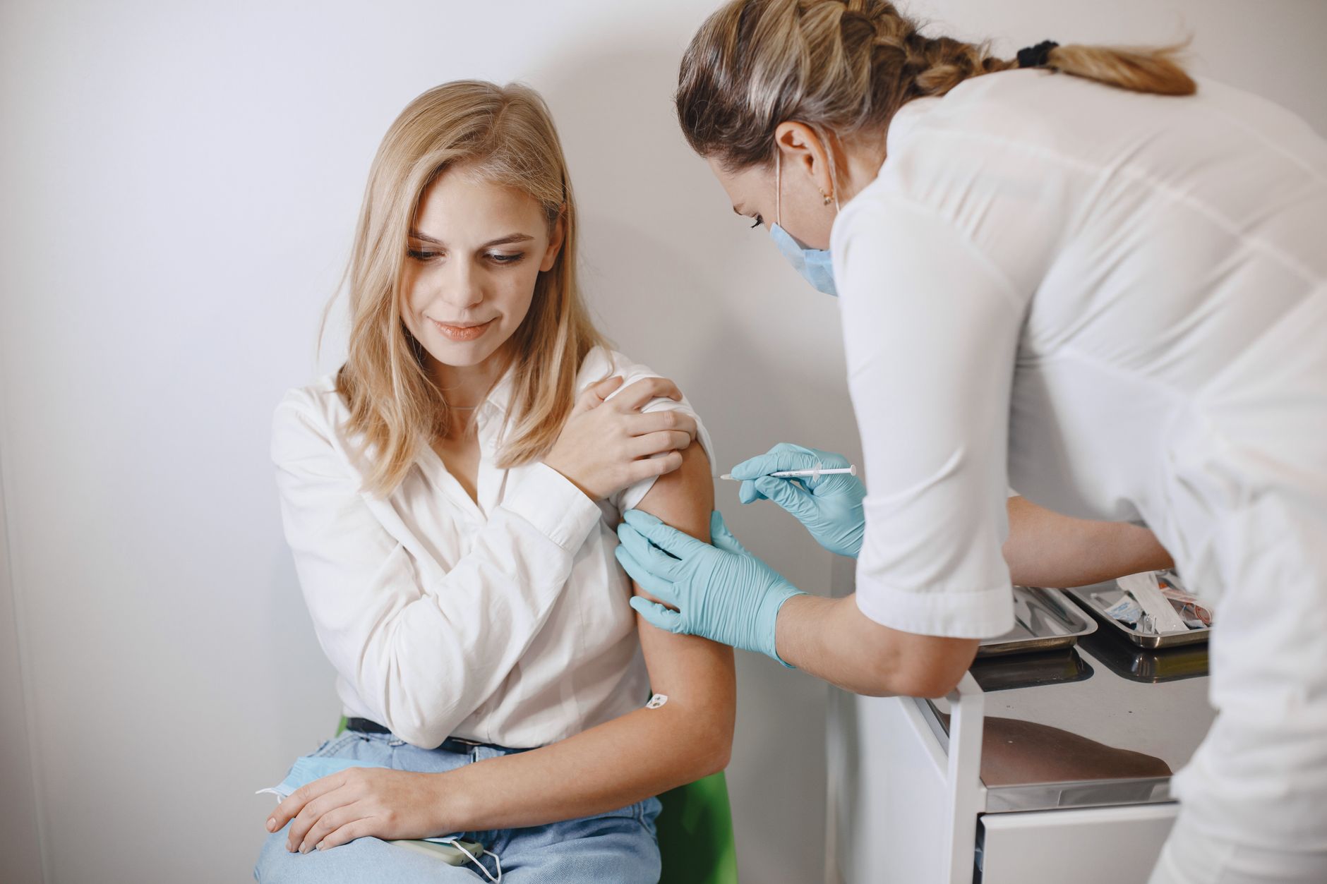 illustration of a pregnant woman receiving a flu shot at a pharmacy, calm setting, focus on the vaccine vial and arm