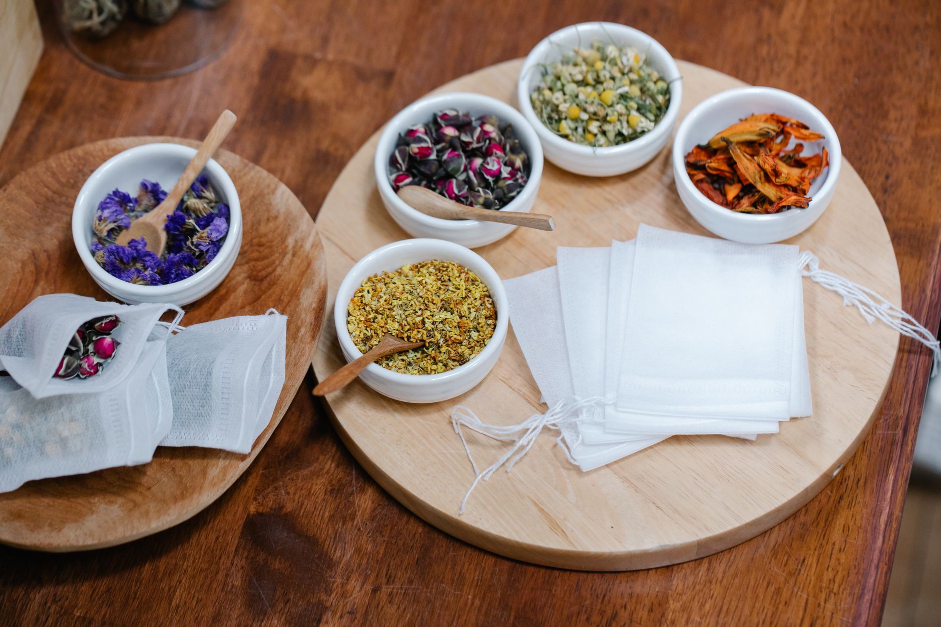 a selection of herbal tea bags arranged on a pastel tray, including ginger, peppermint, and rooibos varieties, soft natural lighting