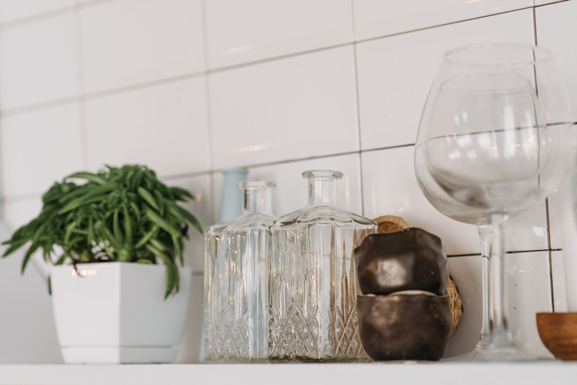a tidy bathroom shelf holding a box of glycerin suppositories next to a bottle of water and a small plant, bright natural light